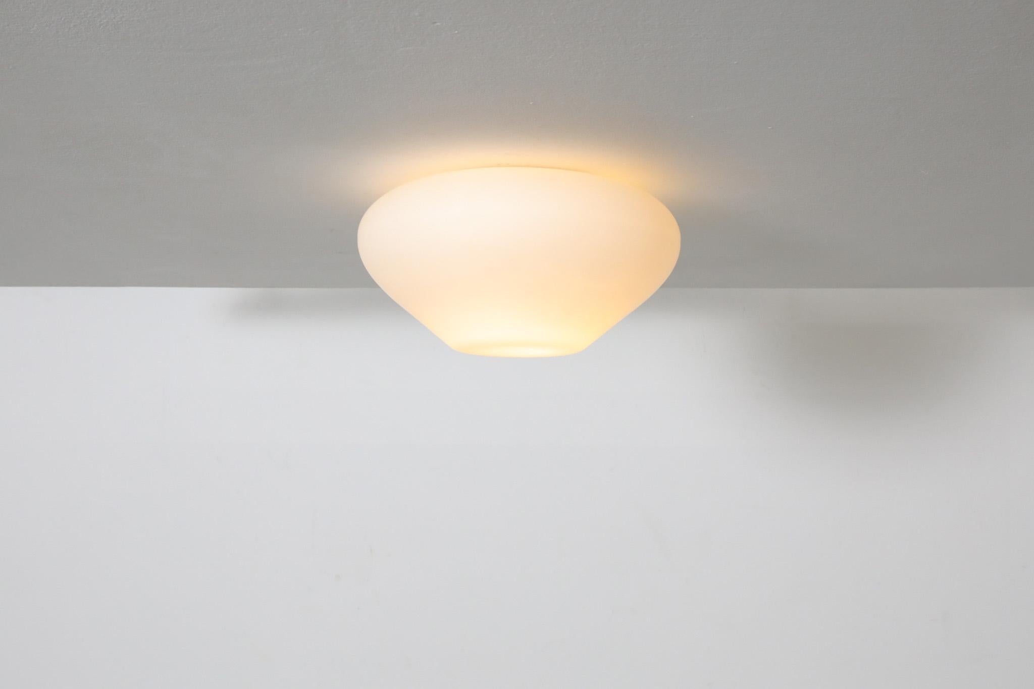 Large Mid-Century flush mount milk glass ceiling sconce. This rounded light has a lovely Hershey's Kiss shape. In original condition with minimal wear, consistent with age and use. 100W Max.