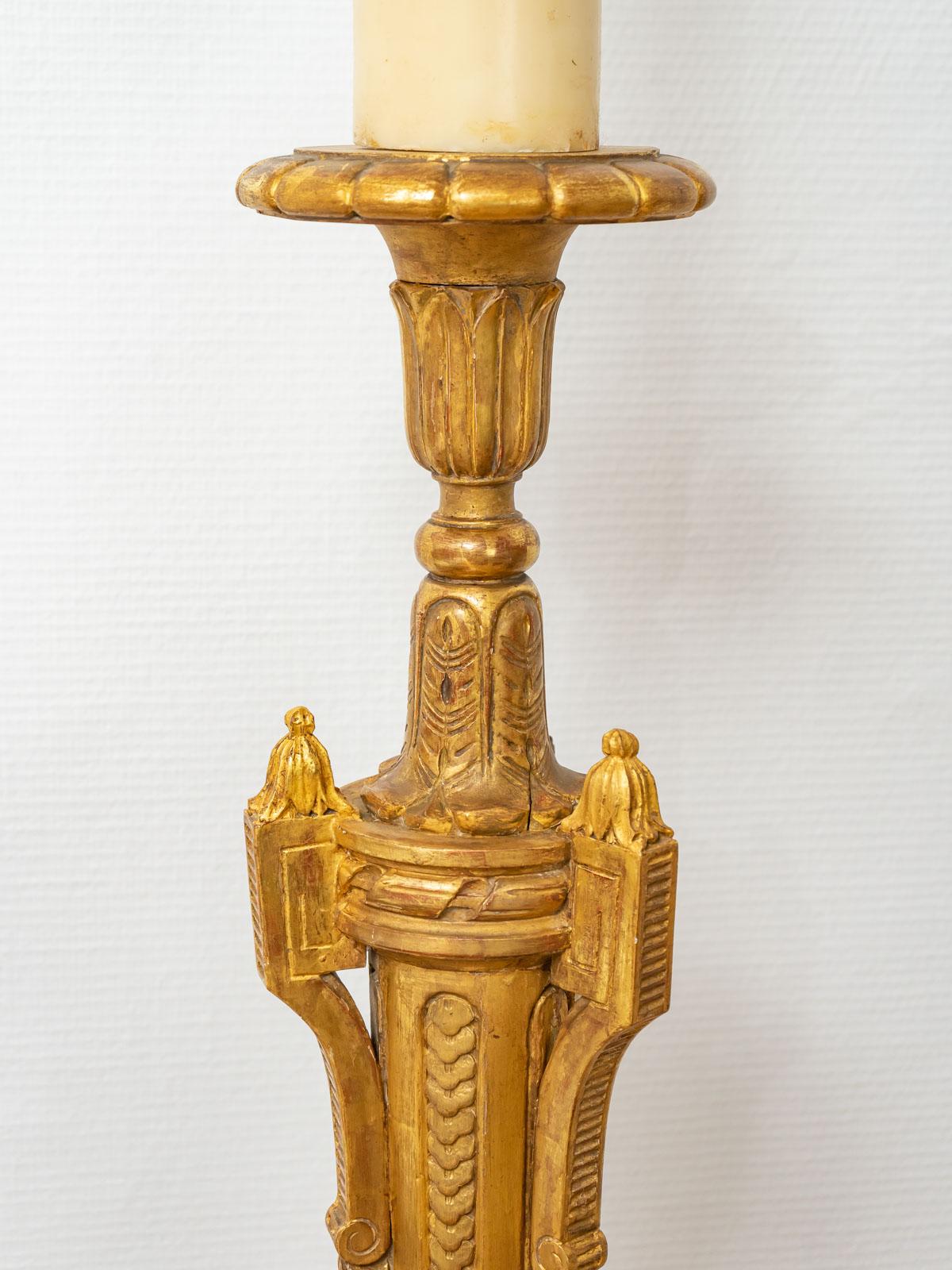 Large carved and gilded wooden candlestick, decorated with foliage, gadroons and acanthus leaves resting on a tripod base.
This sumptuous piece has been restored in our workshops and entirely gilded with 24 carat gold leaf.

Period: 19th