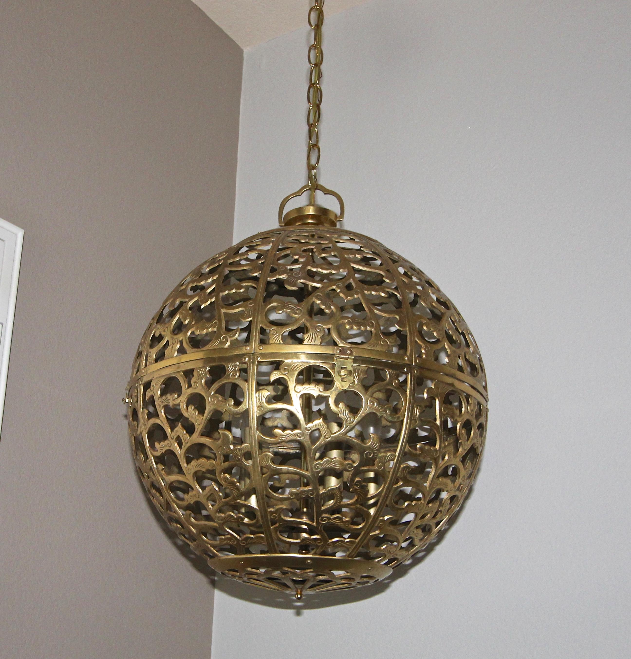 Huge brass pierced Asian chandelier or pendant light with scrolling arabesque pattern motif. Handcrafted from thick solid brass in Japan in the 1950s, this pendant has been refitted with a custom brass 5 light cluster for a more contemporary appeal.
