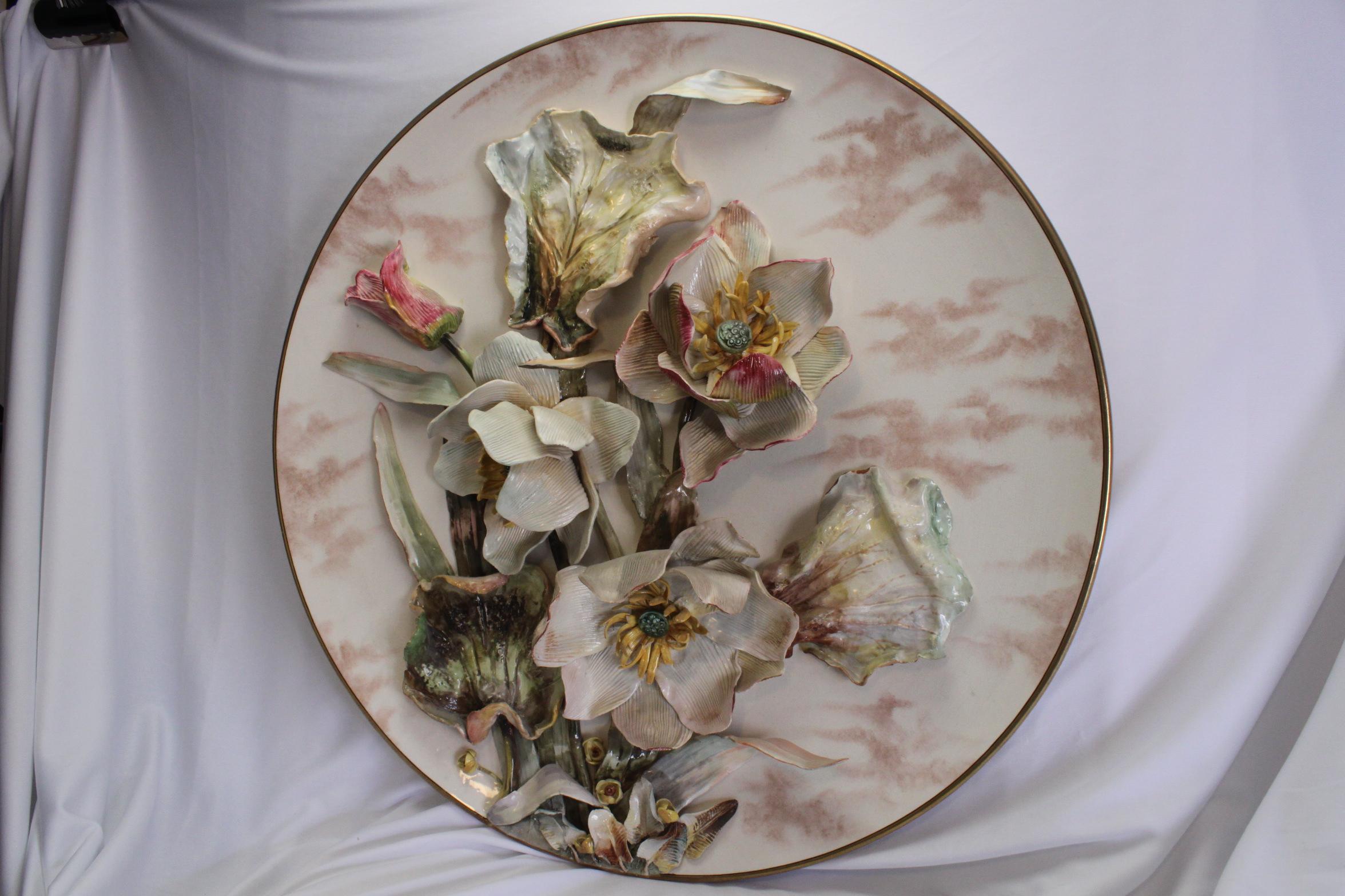 This very attractive large wall plaque is decorated with applied flowers and leaves and bears the impressed mark of Pinder, Bourne and Co of Burslem in Staffordshire. There are four large flowers, several smaller ones and together with some foliage