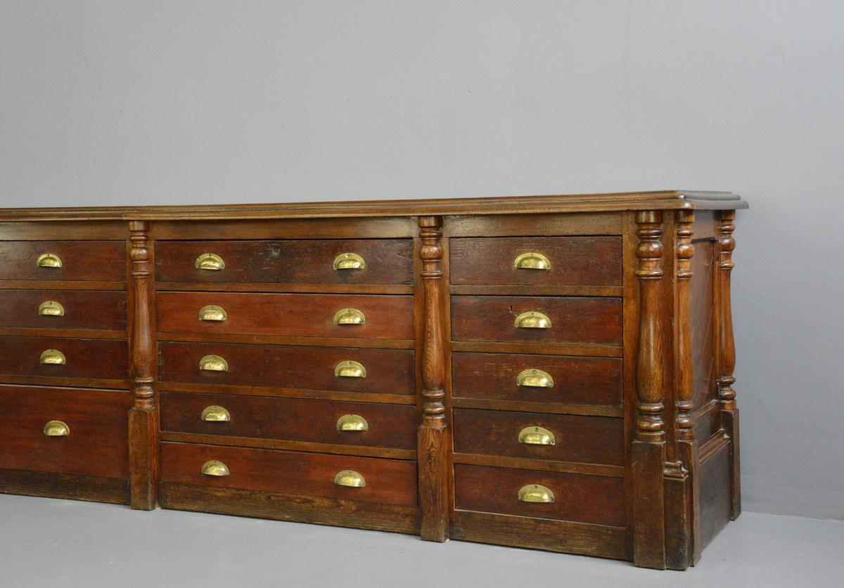 Large pine and mahogany Georgian shop counter

- Pine drawers and frame
- Solid mahogany top with original brass inlaid ruler
- Paneled sides with decorative columns
- Original brass cup handles
- Ruler is stamped with the King George II