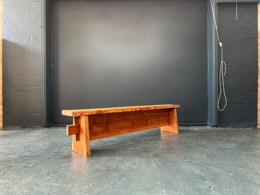 Questa panca in legno di pino è piena di carattere. Realizzata in pino massiccio, presenta una splendida venatura e un telaio angolare che crea un'interessante forma over. Le linee decise e la forma scultorea si integrano con i materiali naturali,