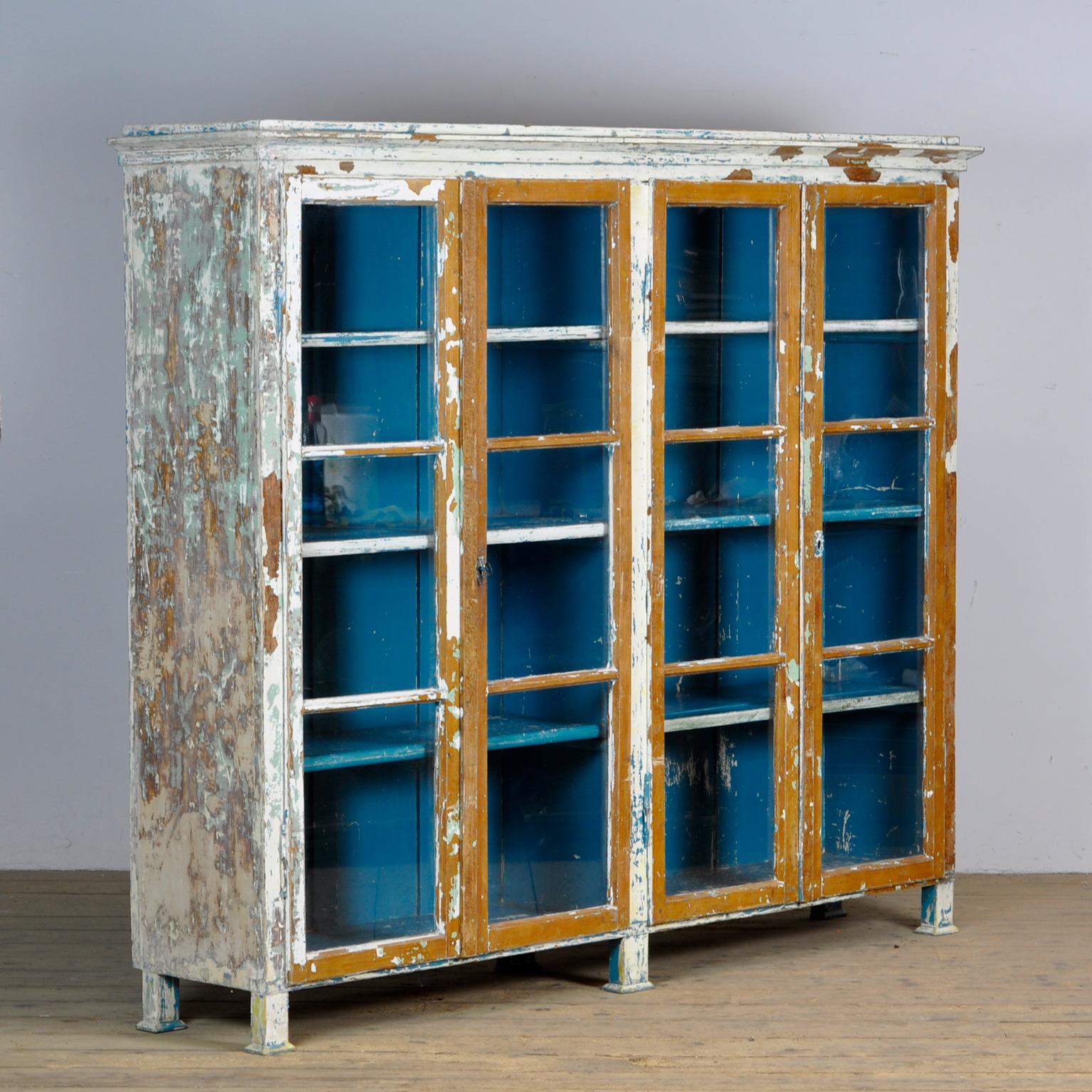 Large pine display cabinet, made around 1930. With four doors and 3 shelves behind them. The cabinet has had different colors over the years, which gives it a beautiful patina. With well-functioning locks.

