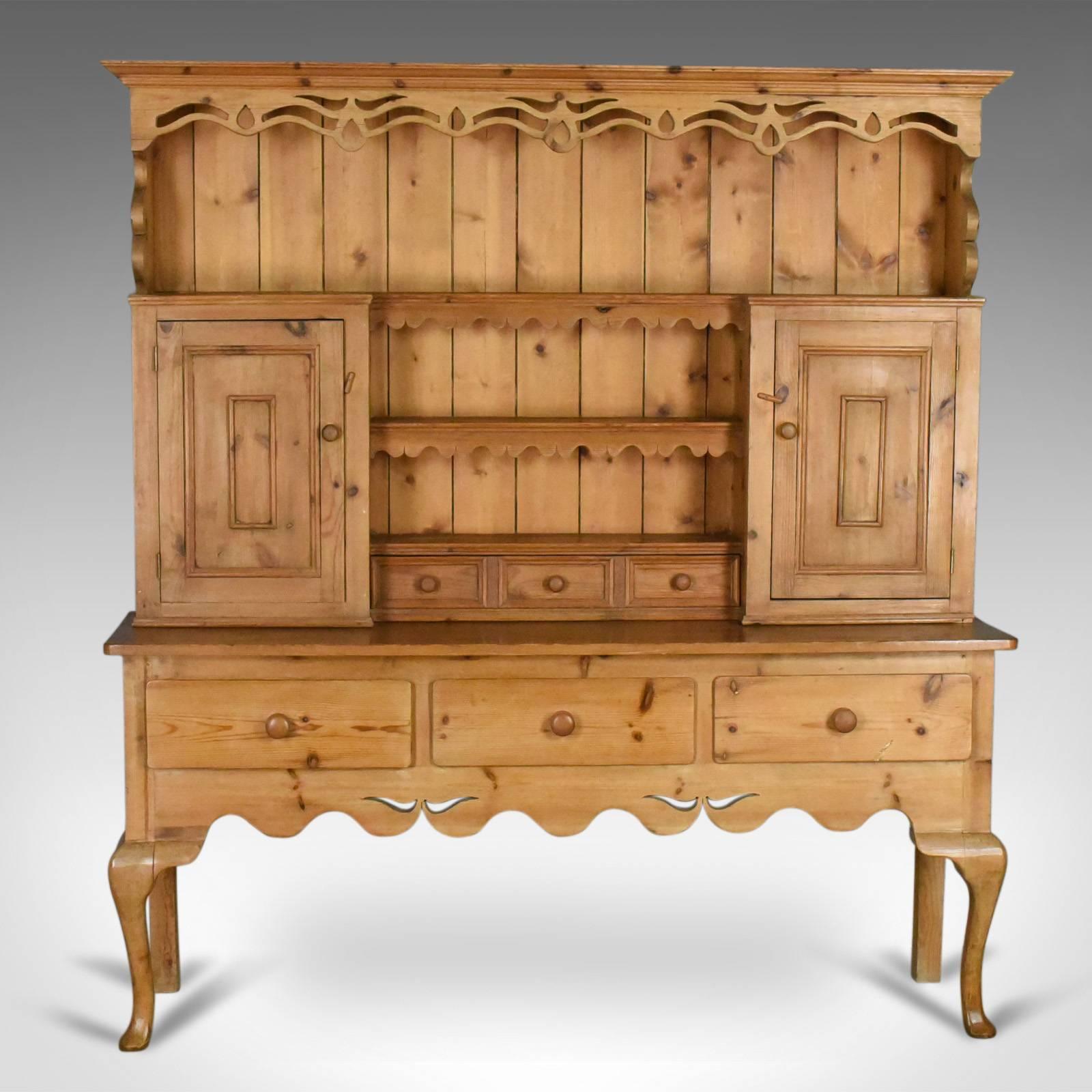 This is a large pine dresser in the Victorian taste, a country kitchen cabinet dating to the late 20th century.

Attractive honey hues in a waxed polished finish
Large proportions offering shelves, cupboards and drawer space
Featuring a tongue