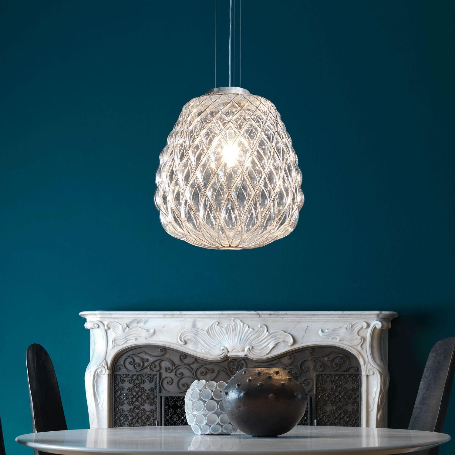 Grande lampada a sospensione 'Pinecone' in vetro trasparente e cromo per Fontana Arte.

Disegnato da Paola Navone, il diffusore è sapientemente realizzato a mano con l'antica tecnica del vetro soffiato a gabbia. In questo caso, il vetraio soffia il