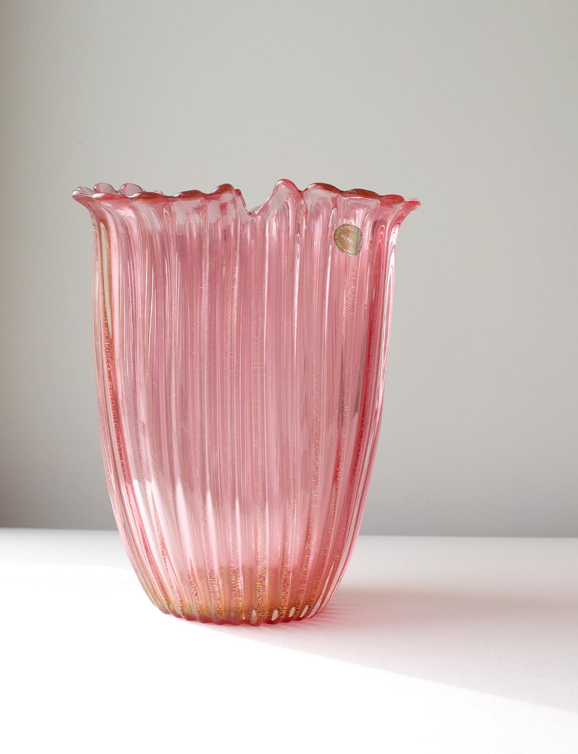An exceptional Archimede Seguso hand-blown Murano glass vase in deep pink with gold flecks throughout. The piece has an elegant three pronged petal like shape and has the original sticker in place. Found in a private home in Rome, it is in very good