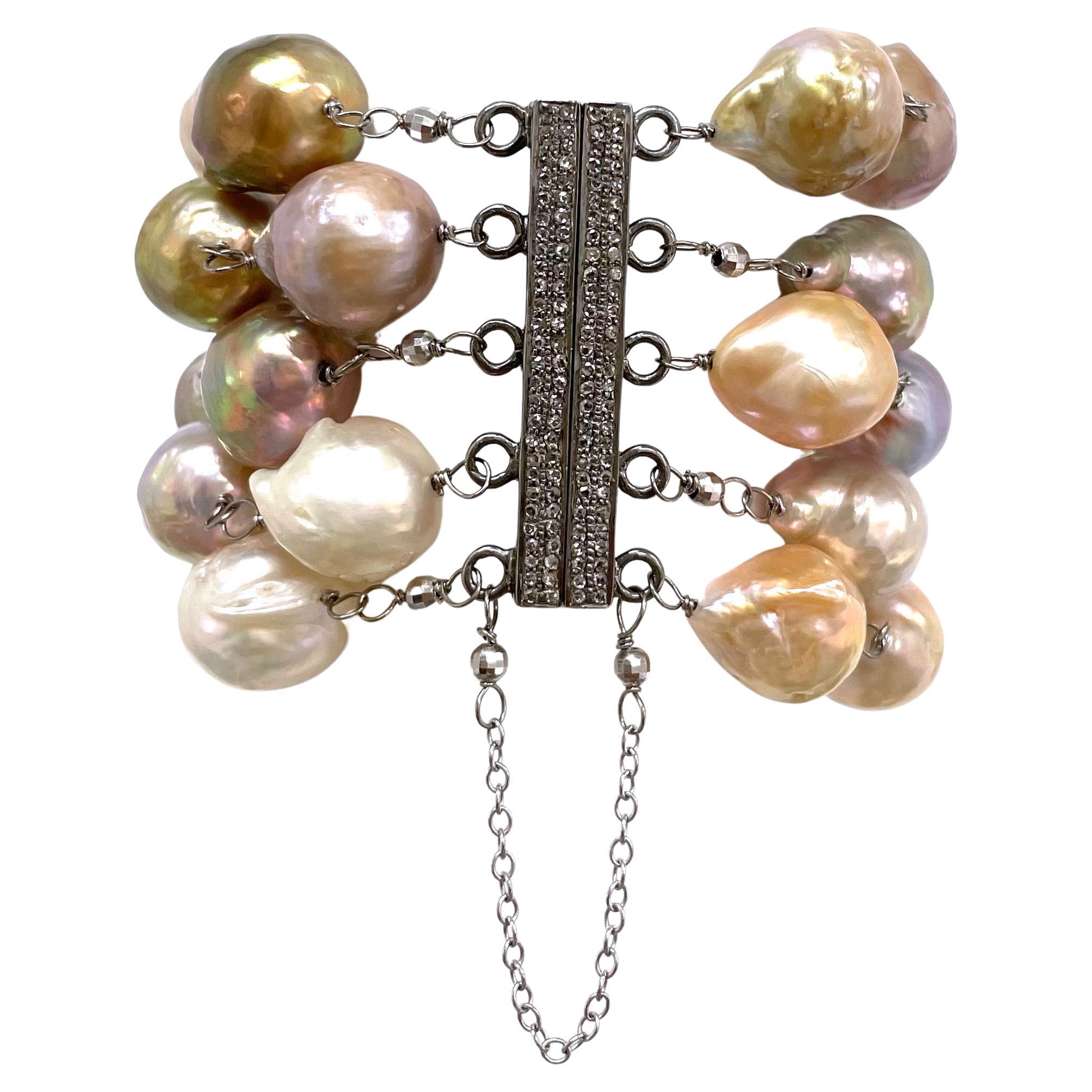 Description
Dramatic, 5 strand large baroque freshwater pearls in all shades of natural pink. The bracelet is embellished with 14k white gold faceted ball accents and a stunning easy to use pave diamond magnetic clasp secured with a safety chain.   