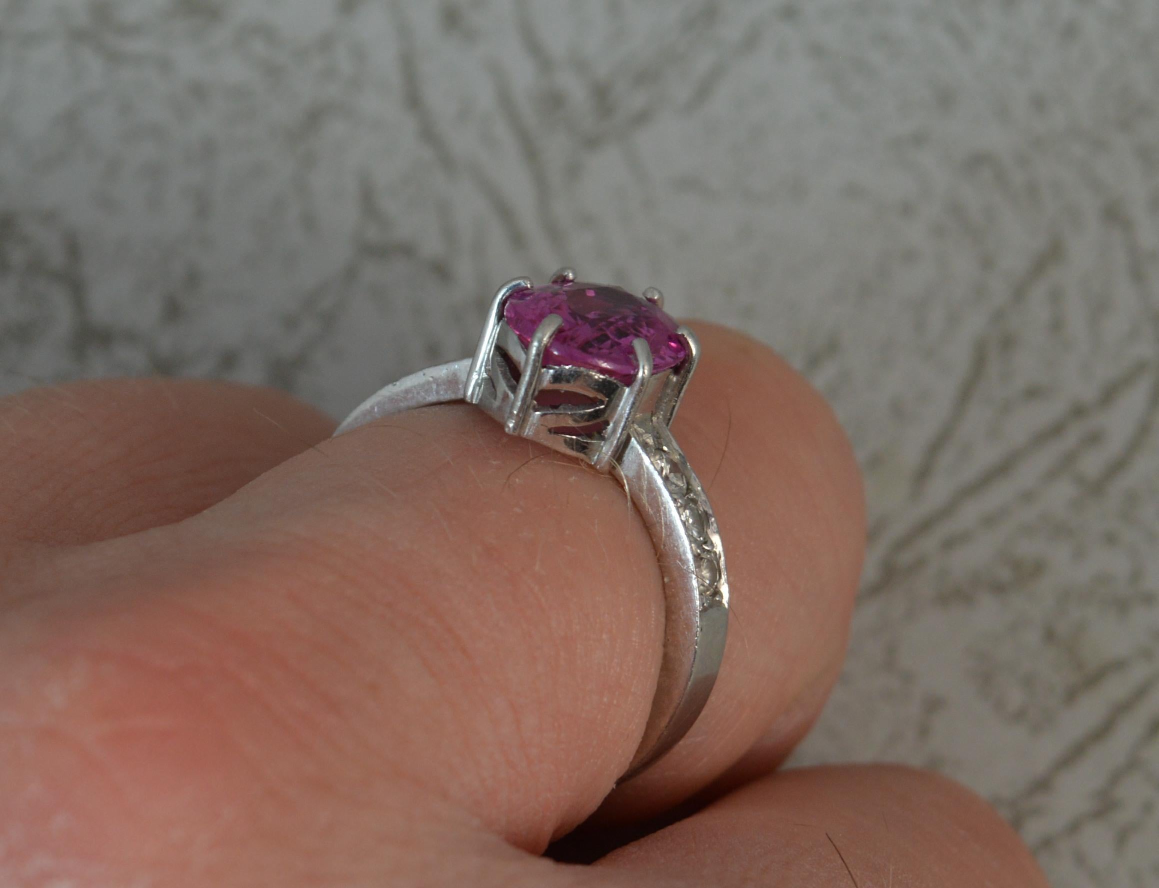 A stunning quality Pink Sapphire and Diamond ring in Platinum.
​An oval cut vivid pink sapphire to centre in six claw setting. 7.9mm x 10.2mm approx.
To each should are three natural round cut diamonds.

Condition; Excellent. Clean and solid band.