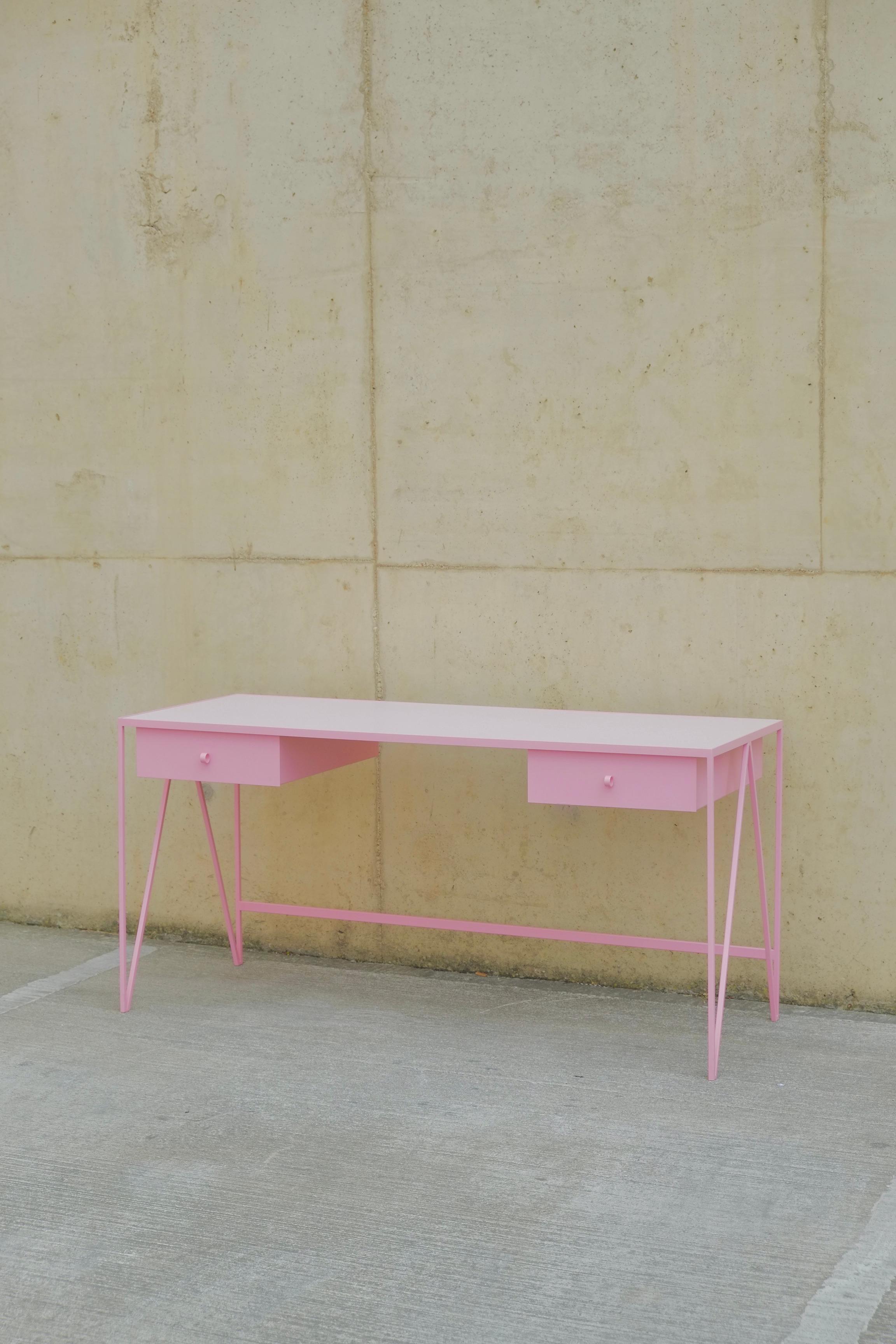 This large pink study desk is made with a powder coated steel frame and a beautiful lacquered plywood table top in pink. This modern minimal desk has two steel drawers suspended underneath the tabletop with our Loop handles. The deep green study