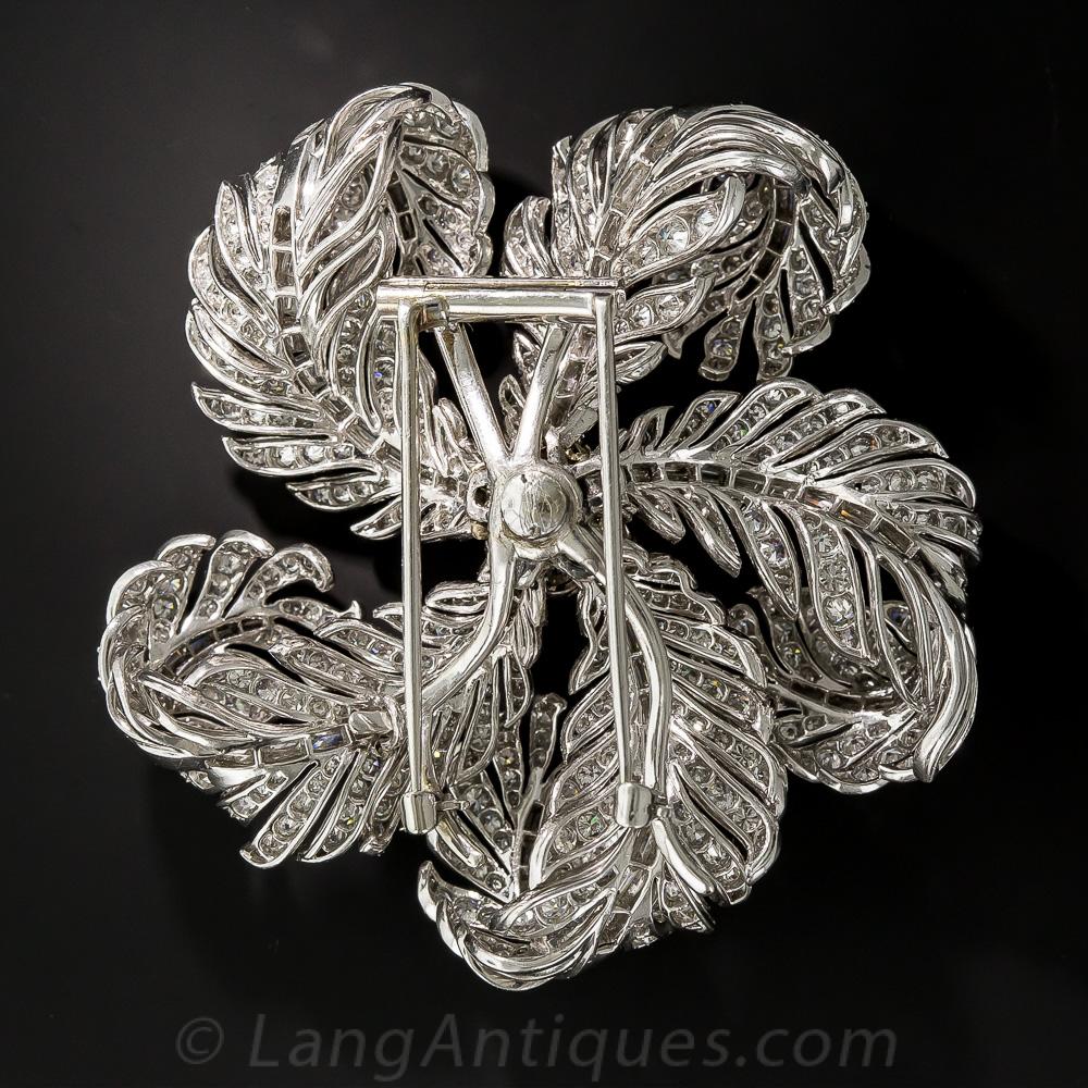 A sparkling kinetic pinwheel design comprised of blinding bright-white diamond feathers make for the most magnificent and mesmerizing corsage brooch ever! Measuring in at an impressive 2 and 5/8 inches, this opulent, multi-dimensional ornament