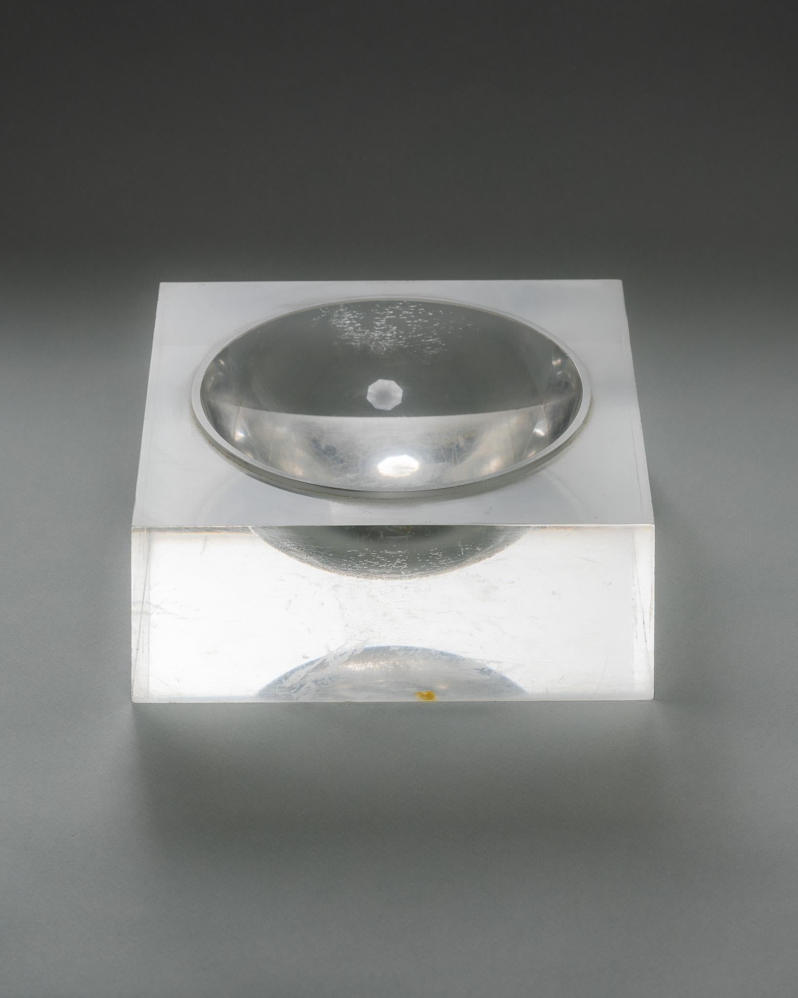Large square catchall or ashtray in molded plexiglass. Minimalist form with a wide circular basin, typical of 1970s design. Beautiful transparency and clean lines, recalling the creations of the Space Age aesthetic.
A few light surface scratches