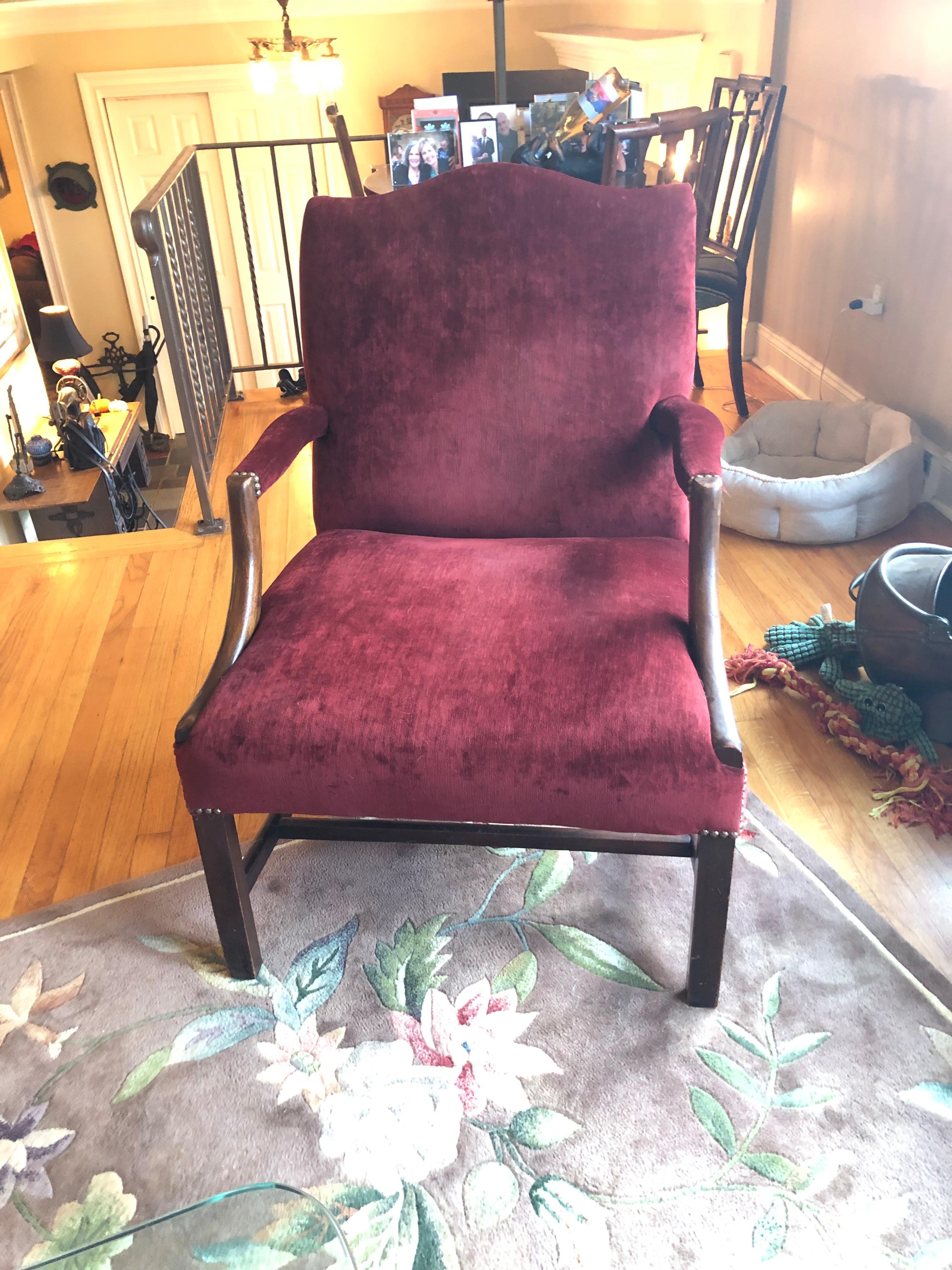 19th century roomy comfortable large Martha Washington style club chair having solid mahogany construction and plush burgundy velvet upholstery with nailhead detailing.