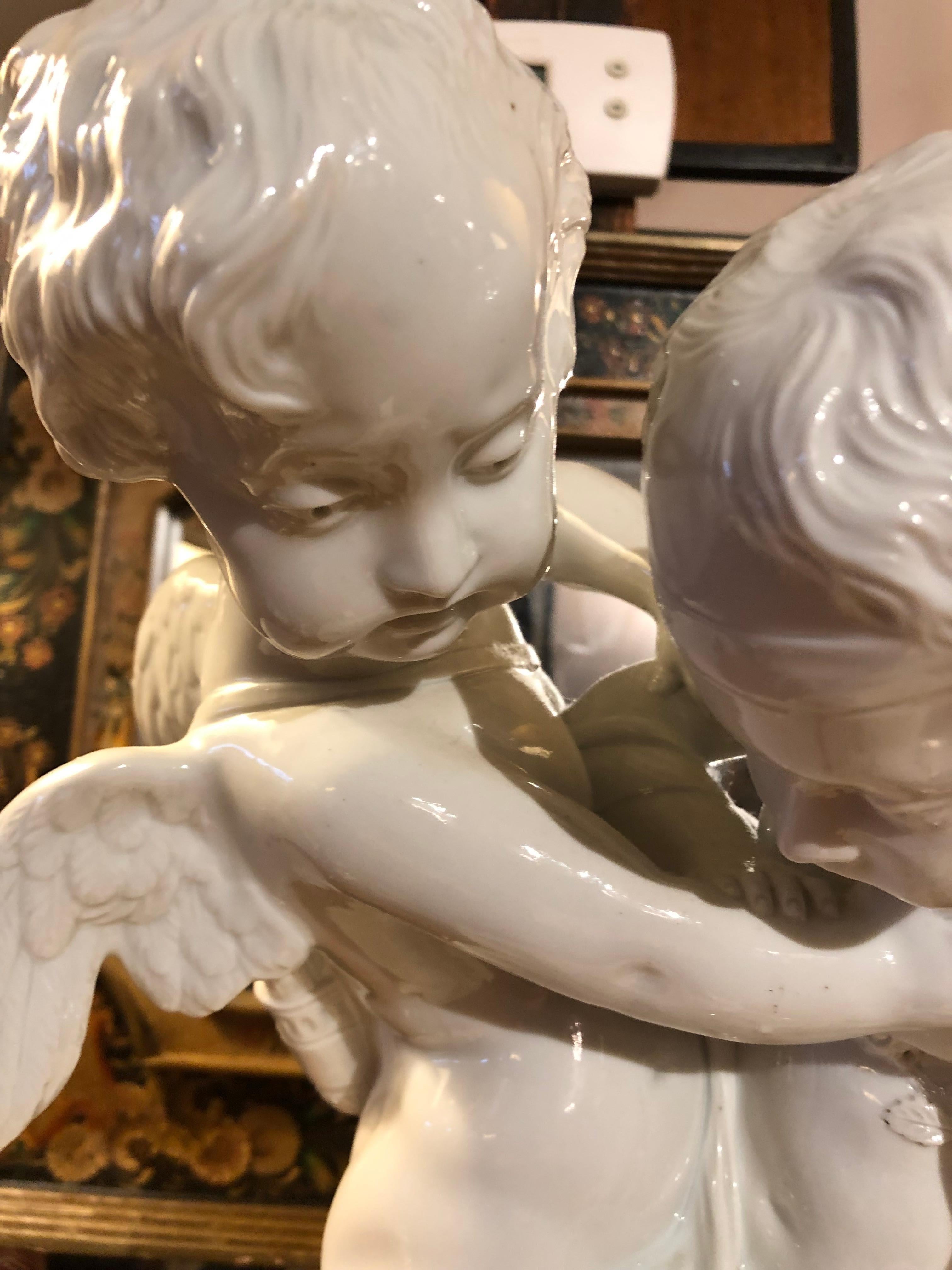 Large white porcelain sculpture of two cherubs caught in a lovely pose and having amazing details.