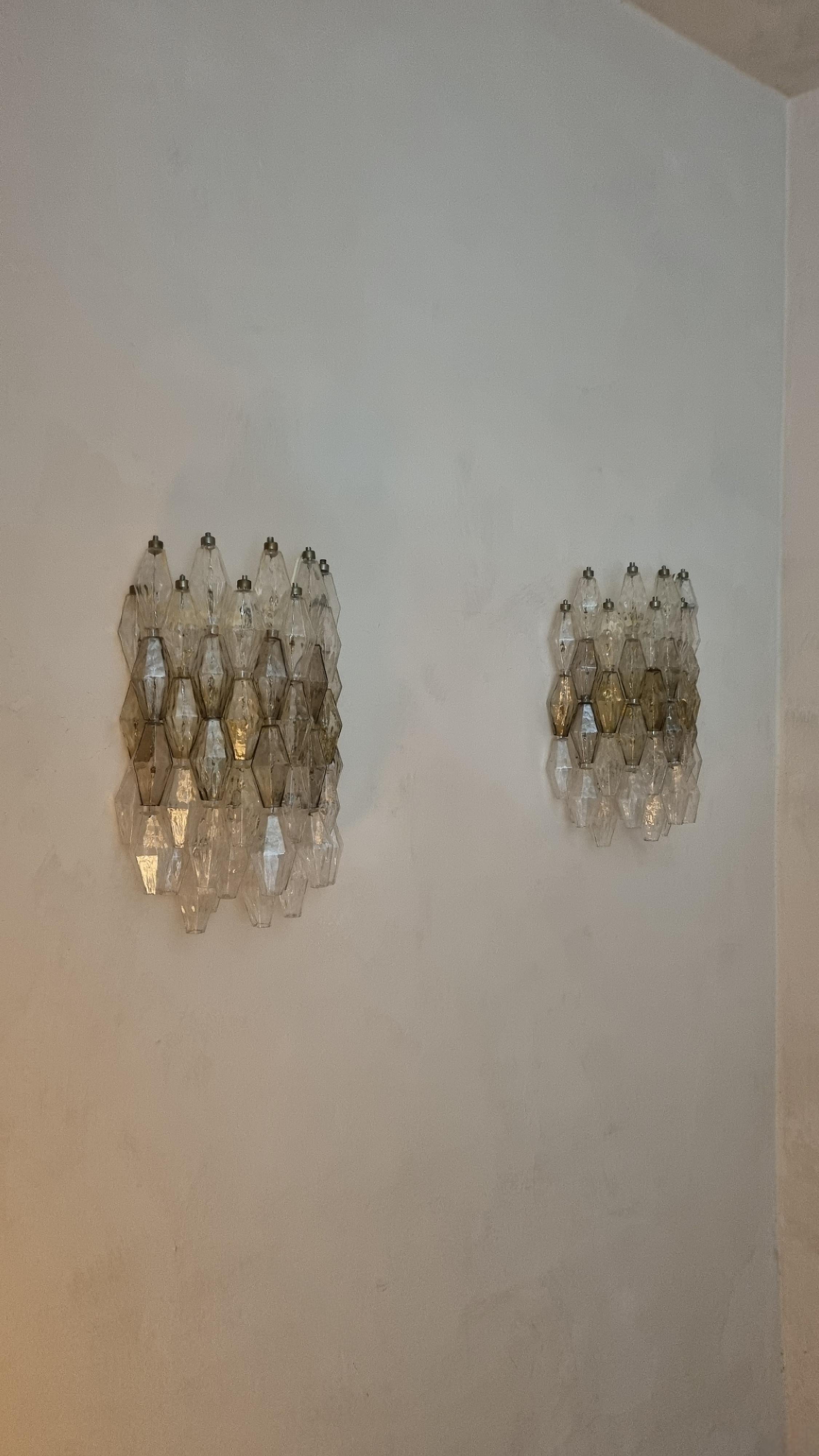 Grandi lampade a parete Poliedri disegnate da Carlo Scarpa nel 1958 per vetreria Venini. 
Struttura in metallo verniciato, vetro soffiato nei toni trasparente e fumè, nella rara versione composta da 48 poliedri, eccellenti condizioni, impianto
