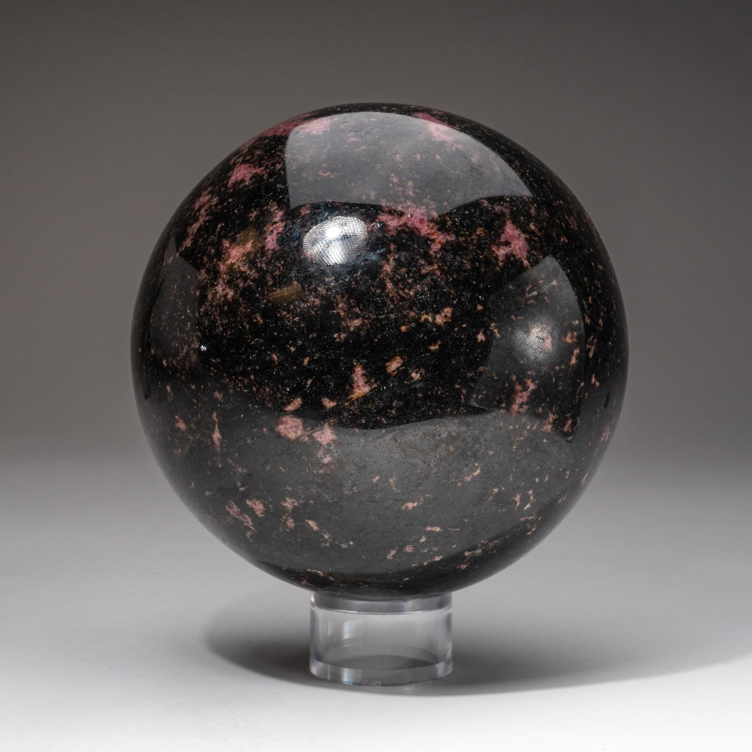 This top-quality hand-polished natural Imperial Rhodonite Sphere from Madagascar exhibits an exquisite pattern with vivid hues of pink and red. When used, the Rhodonite stone activates and balances the heart, clearing away past wounds and promoting