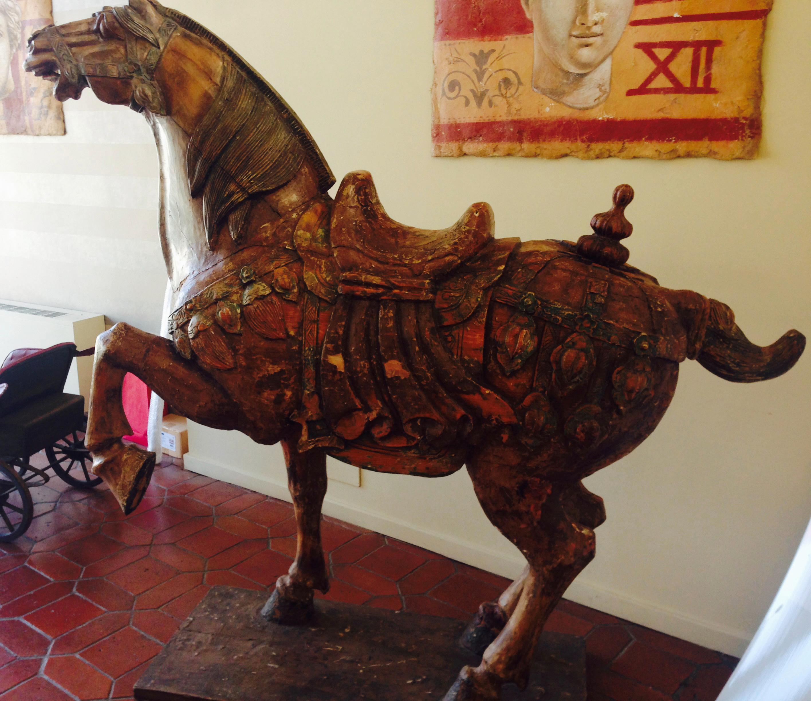 Sizable hand carved polychrome Chinese horse sculpture with detailed decoration.