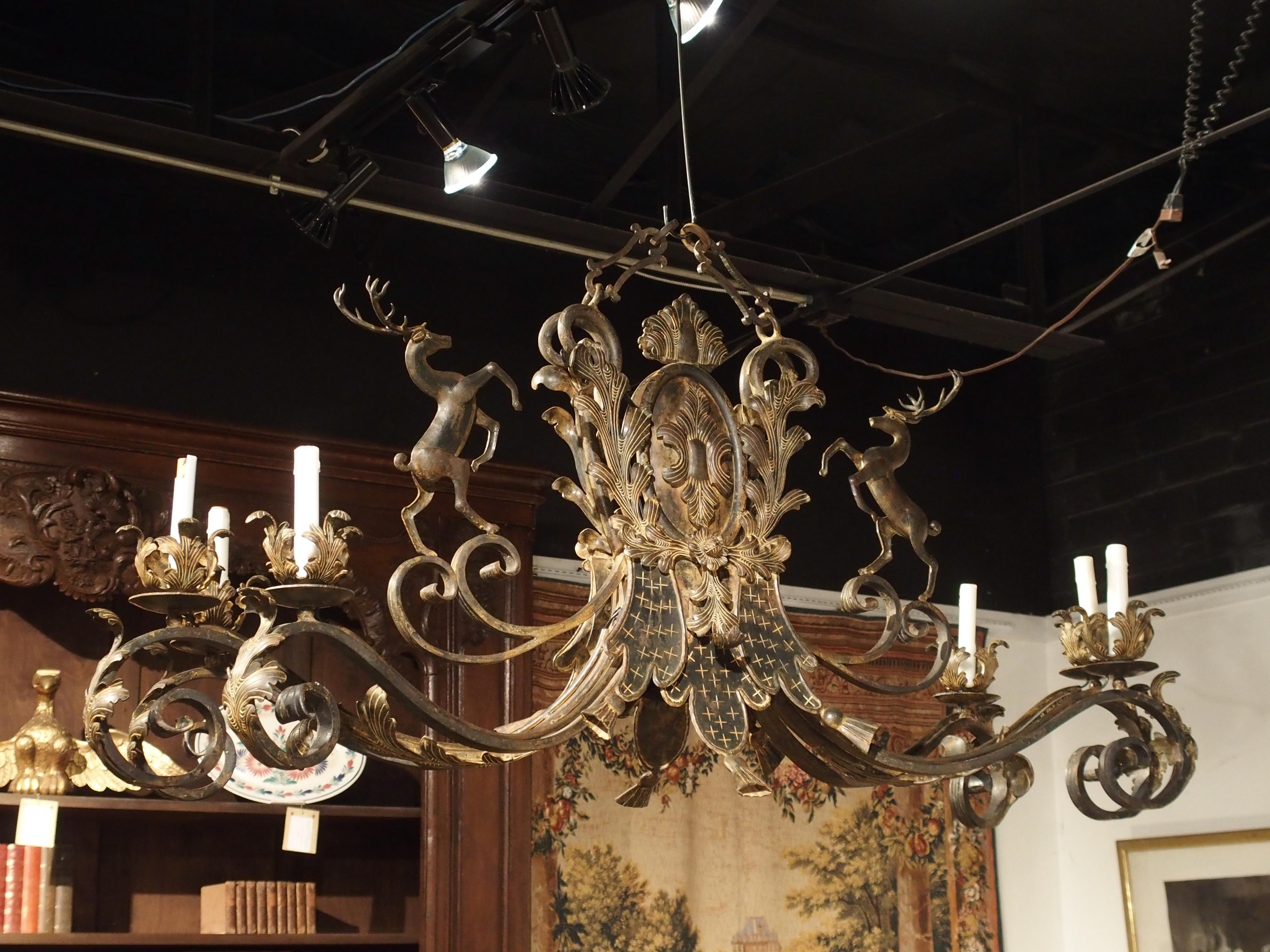 This expansive wrought iron and tole chandelier from France measures over 5 feet long and would be an ideal fit in a room such as a library, dining room, game room, or hanging over a long kitchen island.

The chandelier is composed of a mix of