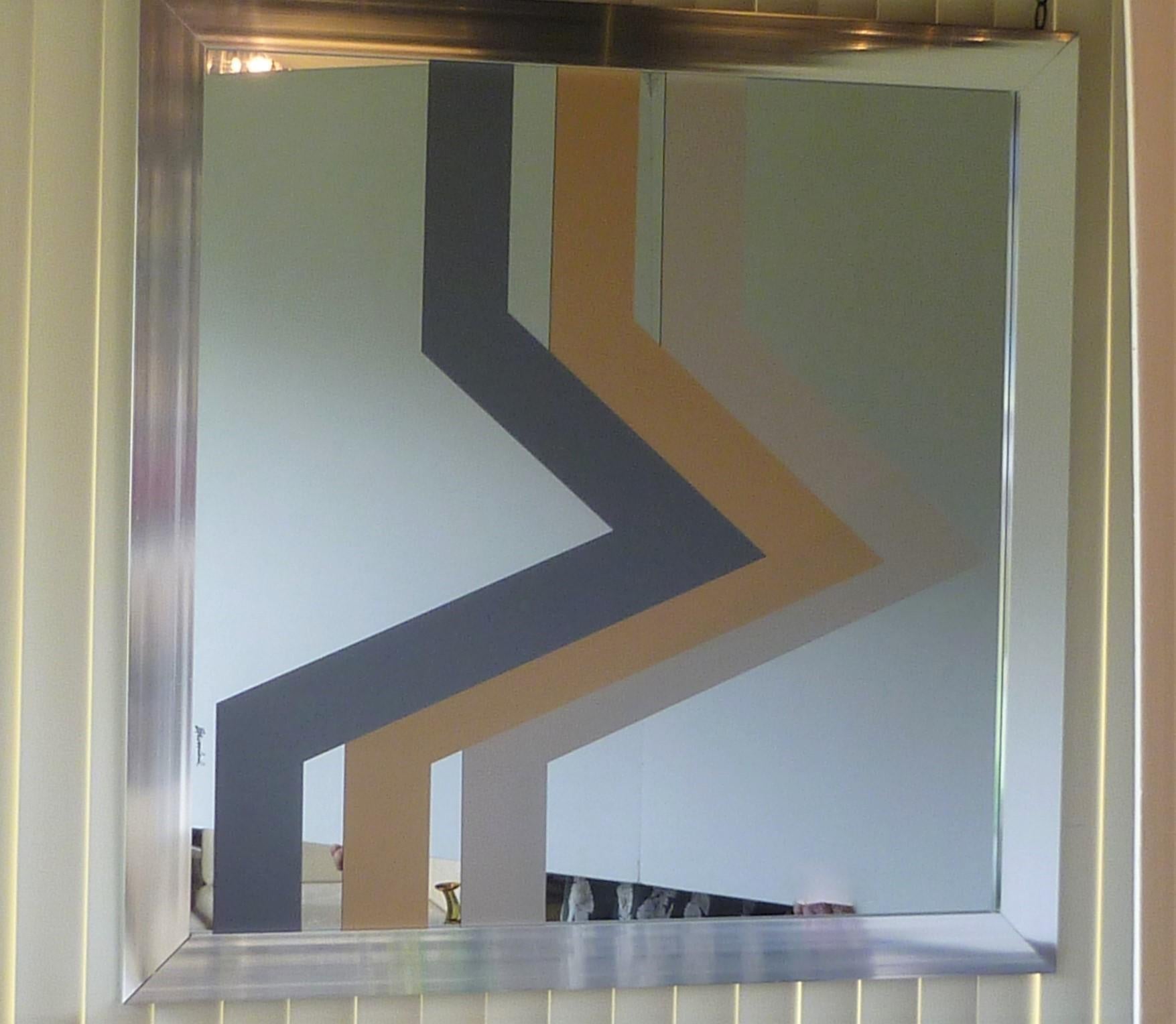 Large metal frame mirror with a pop op graphic geometric design from 1975 and from the firm Expressions. Modern and ageless, working well today as when created. Signed in the design. Mostly mirror with design in three color graphic in gray,