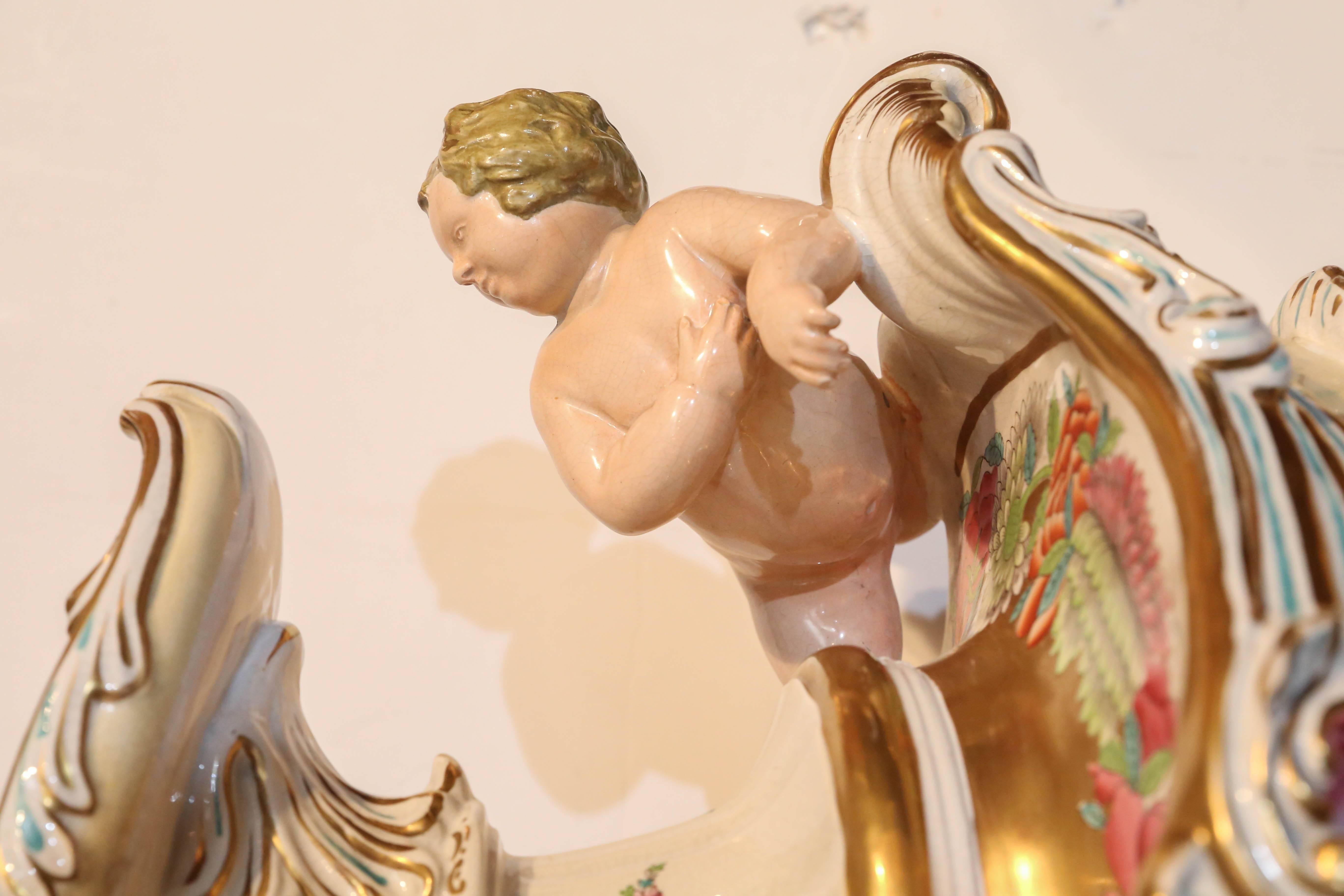 Steinmetzkrug mit geschwungenem Henkel, sehr fein bemalt
Mit Blumen und exotischen Vögeln, und auf der anderen Seite ist es gemalt
Mit vier asiatischen Figuren und einer Gartenszene.
Ein Paar Putten ziert den oberen Teil des
Die Vase, vergoldete