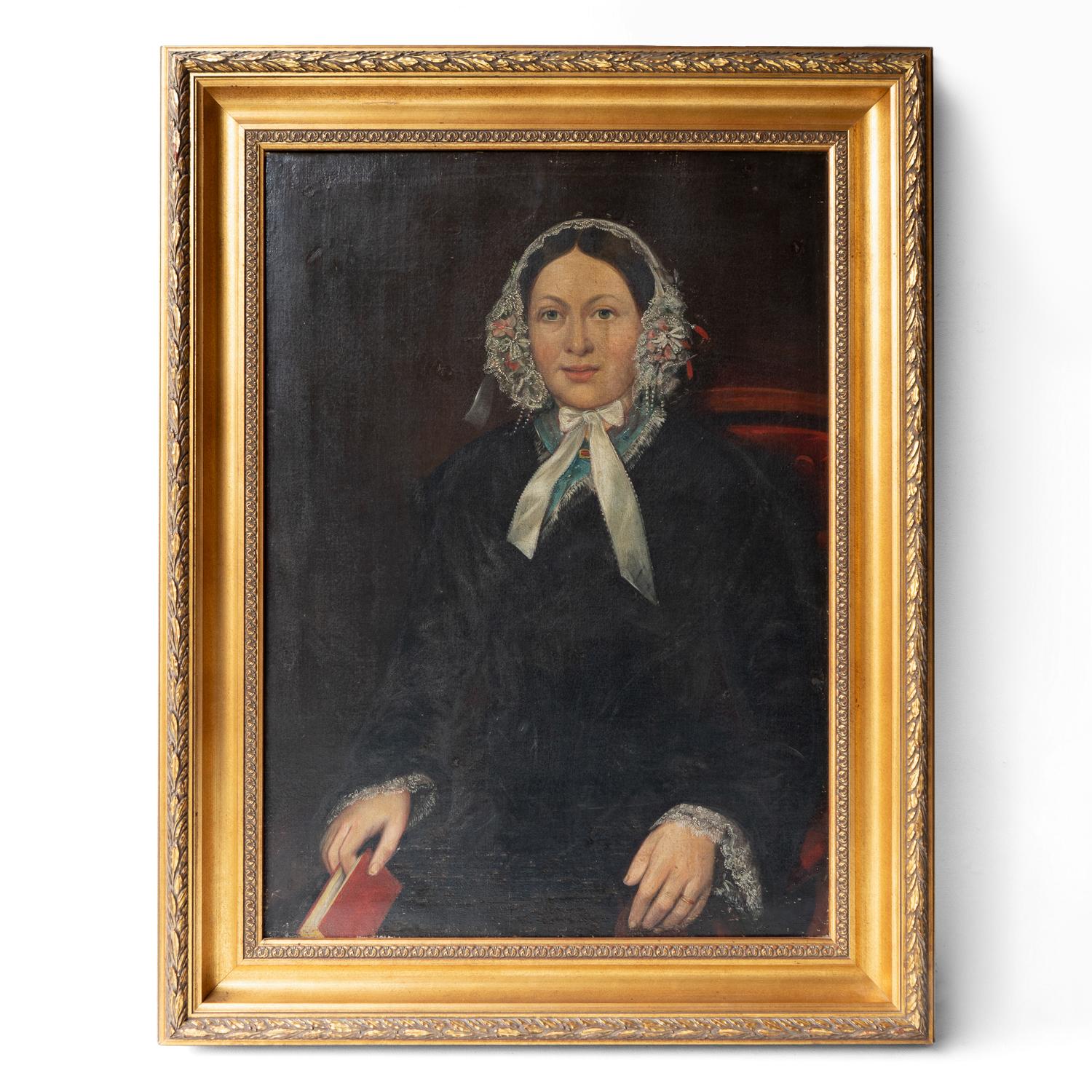 ANTIQUE ORIGINAL OIL ON CANVAS PAINTING DEPICTING A FEMALE SITTER
Depicting a woman with a warm face and friendly pale blue eyes. She is sitting on a red button-backed chair wrapped in a black velvet cloak with a lace cap on her head with flowers.