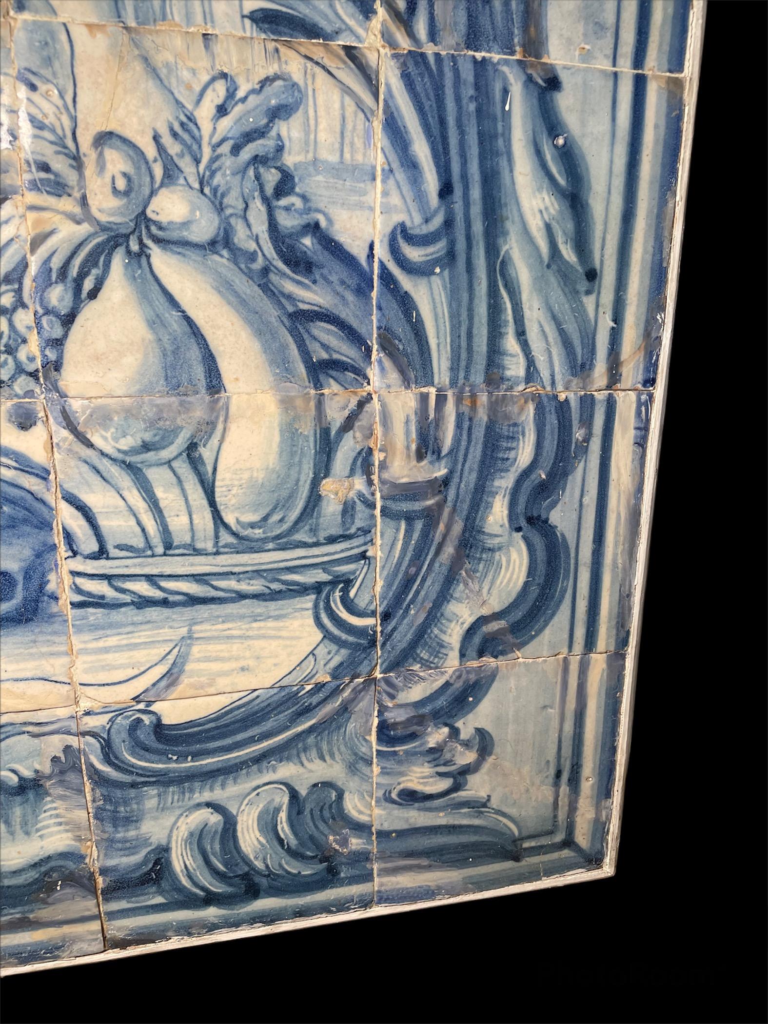 This is a large heavy wood framed mural made of Portuguese “Azulejos” or white and blue tiles. It depicts a scene at the countryside where a peasant lady after gathering some fruits in a basket is relaxing below a tree and trying a fruit herself. A