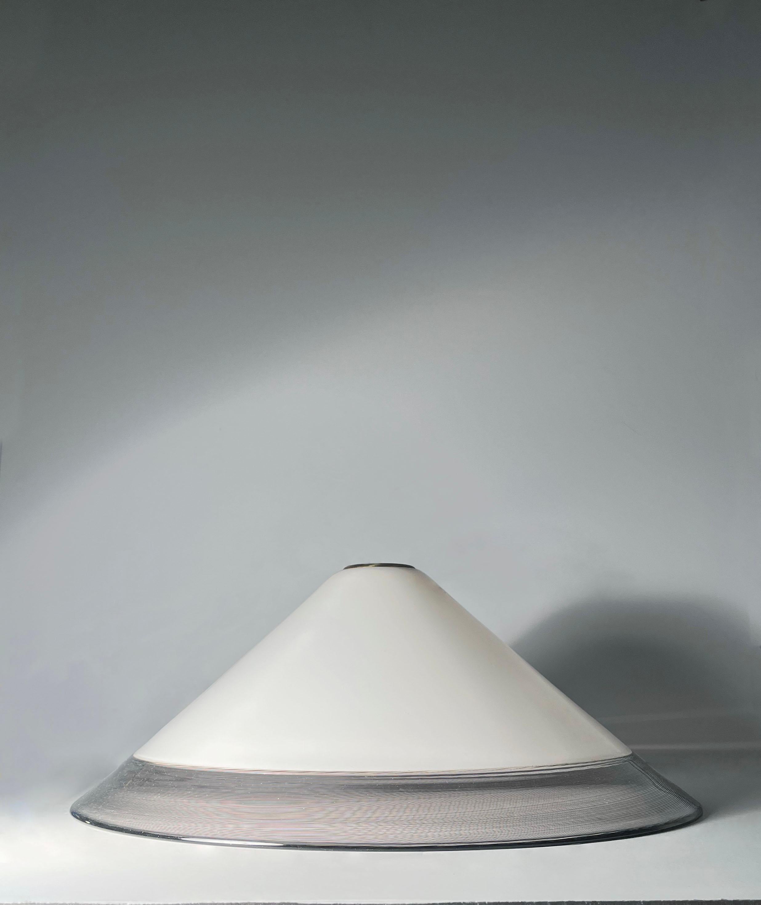 A Large Post Modern Art Glass Pendant Lamp attributed to Venini

A white glass body with a purple threaded rim band. 

Comes with wiring and ceiling cap. Please request additional photos. 

This item will be boxed and then shopped via a in home