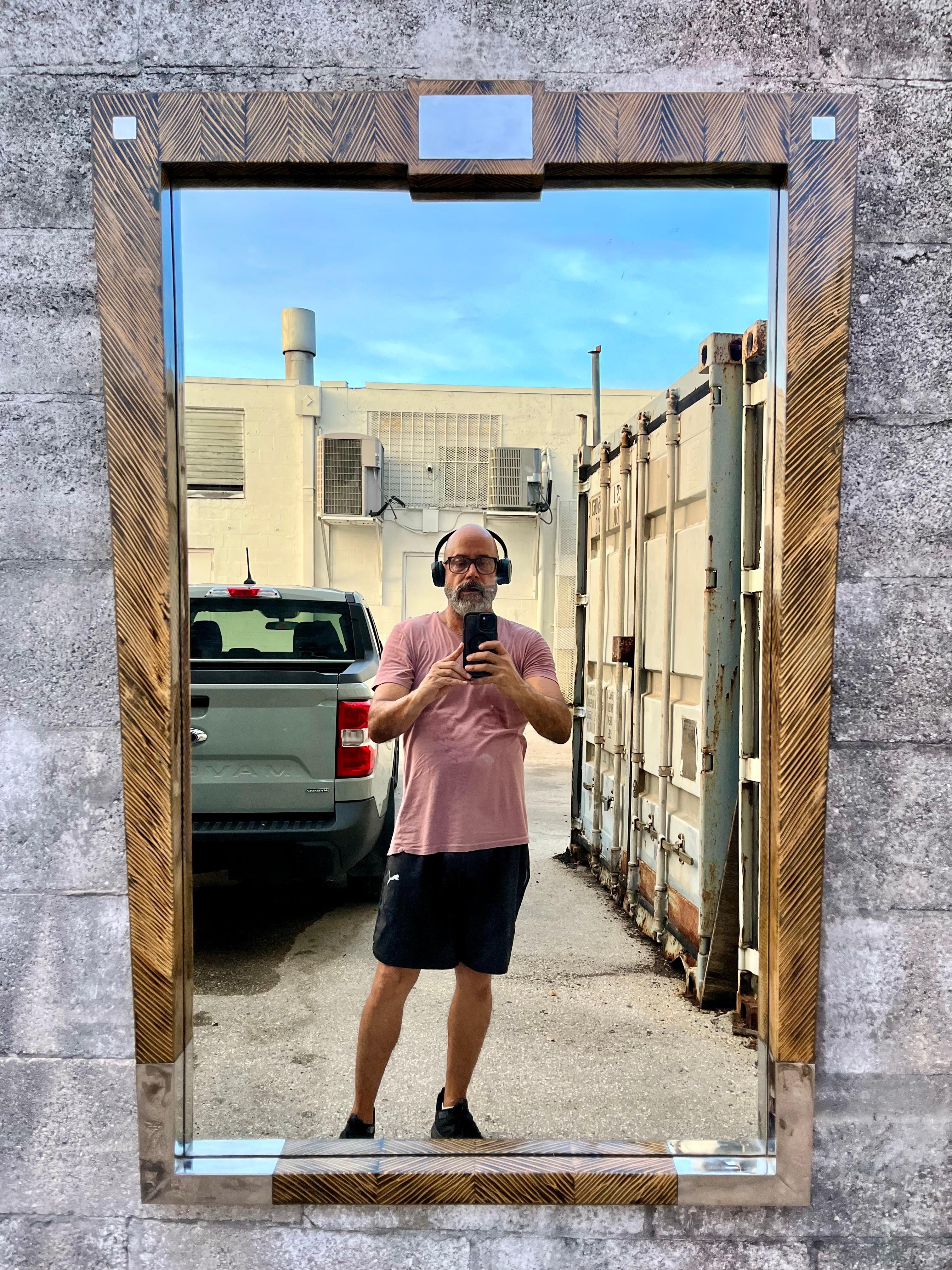 Large Postmodern Coco Wood Wall Mirror by Robb & Stucky. Circa 1990s
Features an asymmetrical solid wood frame with a beautiful lacquered coco wood texture with chrome metal trims. 
In excellent original condition with minimal signs of wear and age.