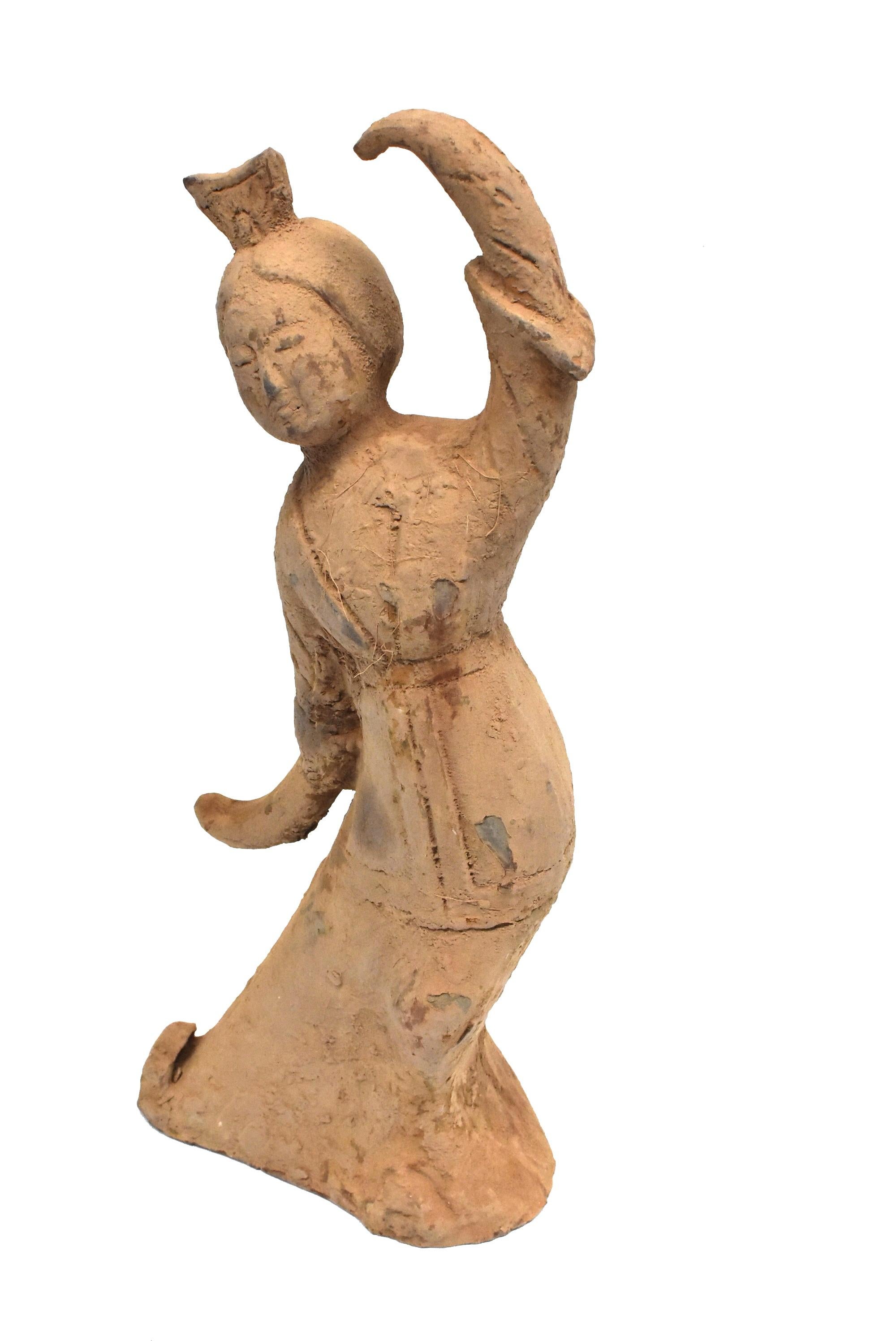 A beautiful large pottery figure, Han style. The figure appears to be dancing. She wears a robe with cinched waist and wide sleeves. A high crown tops her gathered hair. Her facial features are delicate and youthful. 