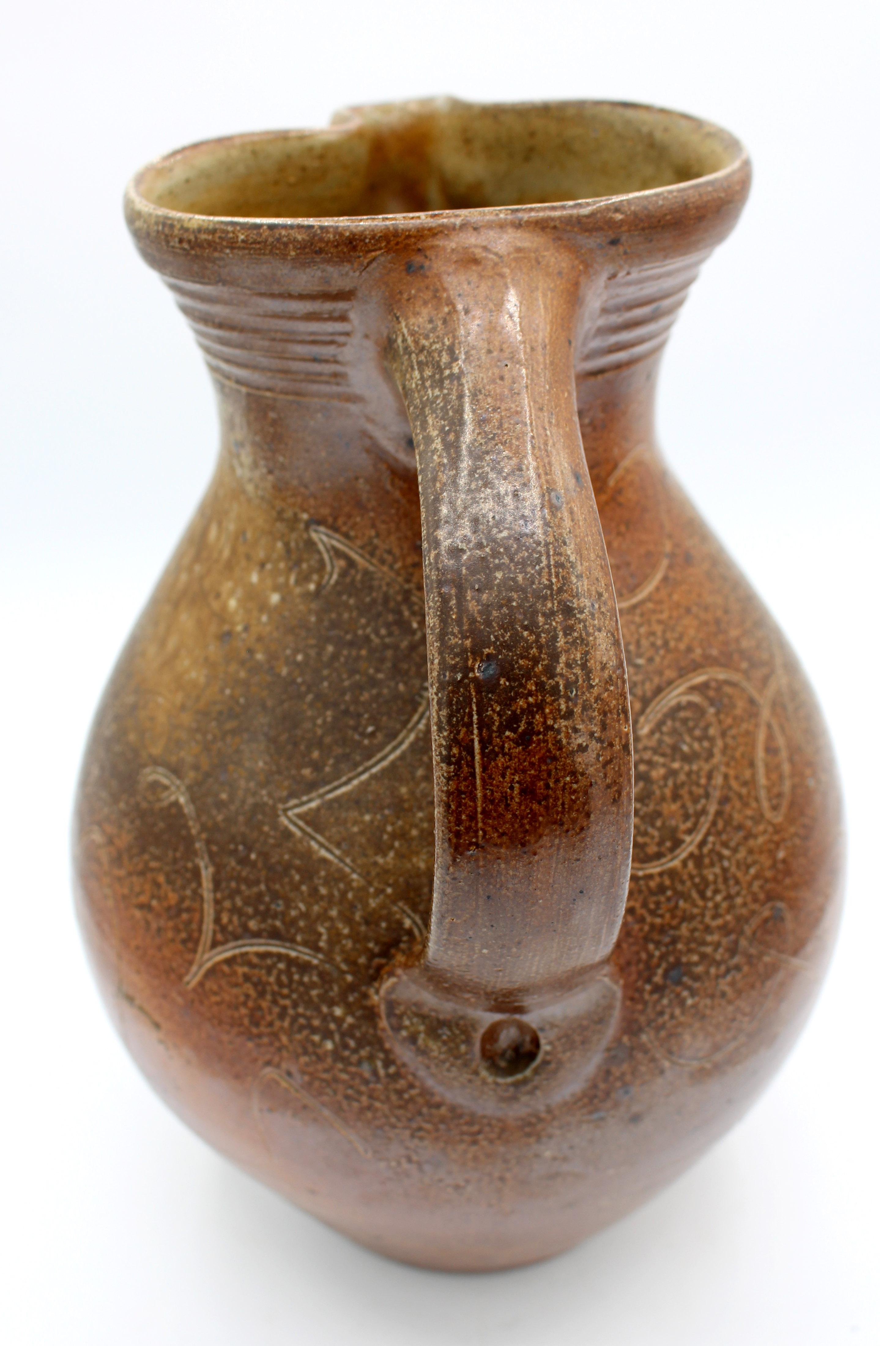 November, 1995 large pottery pitcher by Mark Hewitt, Chatham Co., NC. Incised line design; from Mark's 40th birthday firing (insignia glyph XXXX). Never laying down the stylus, it mimics rare 18th century English decoration.
11.25