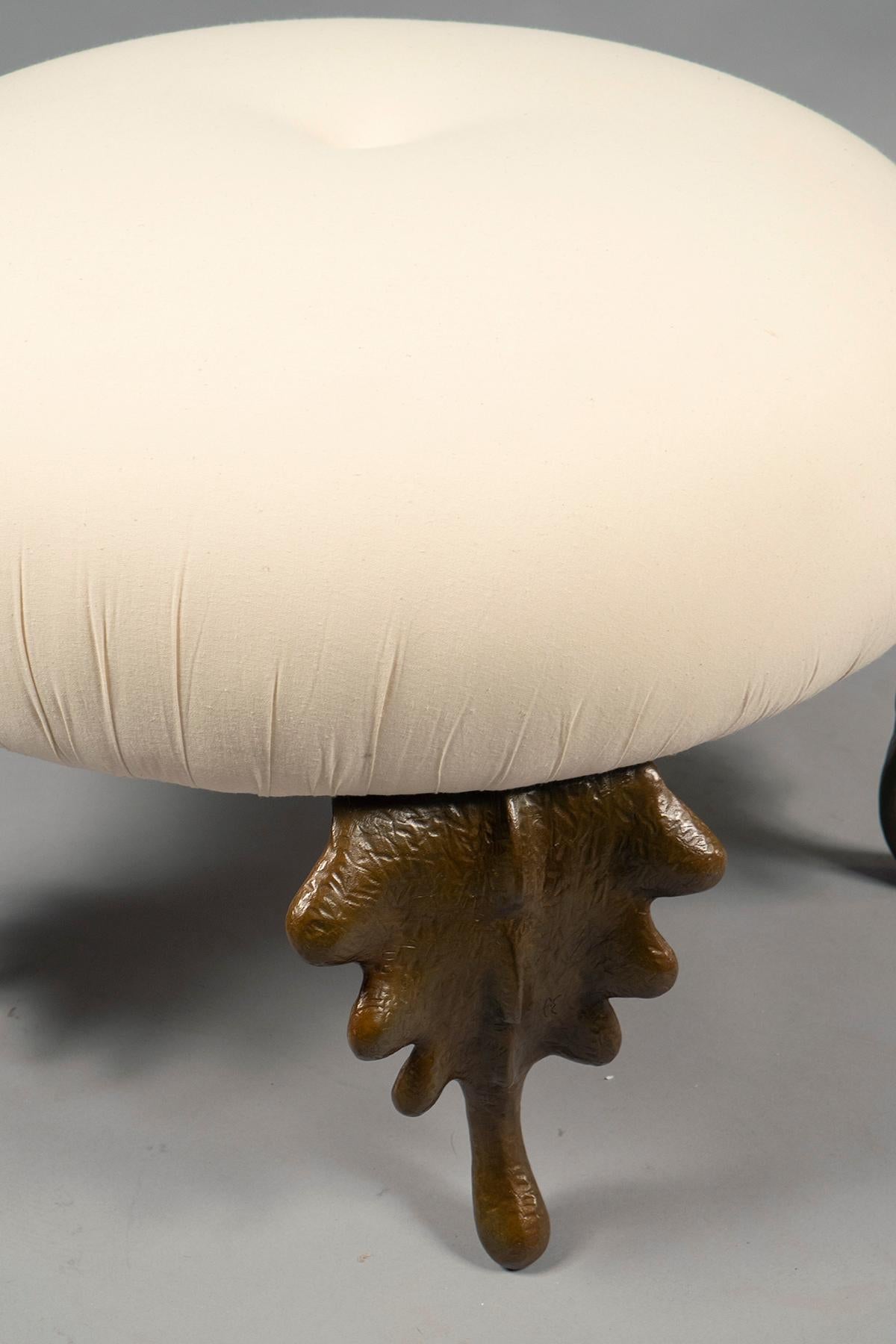 Round cushion featuring one tufted button, supported by five fantastical bronze leaf legs. Custom sizes and finishes available.