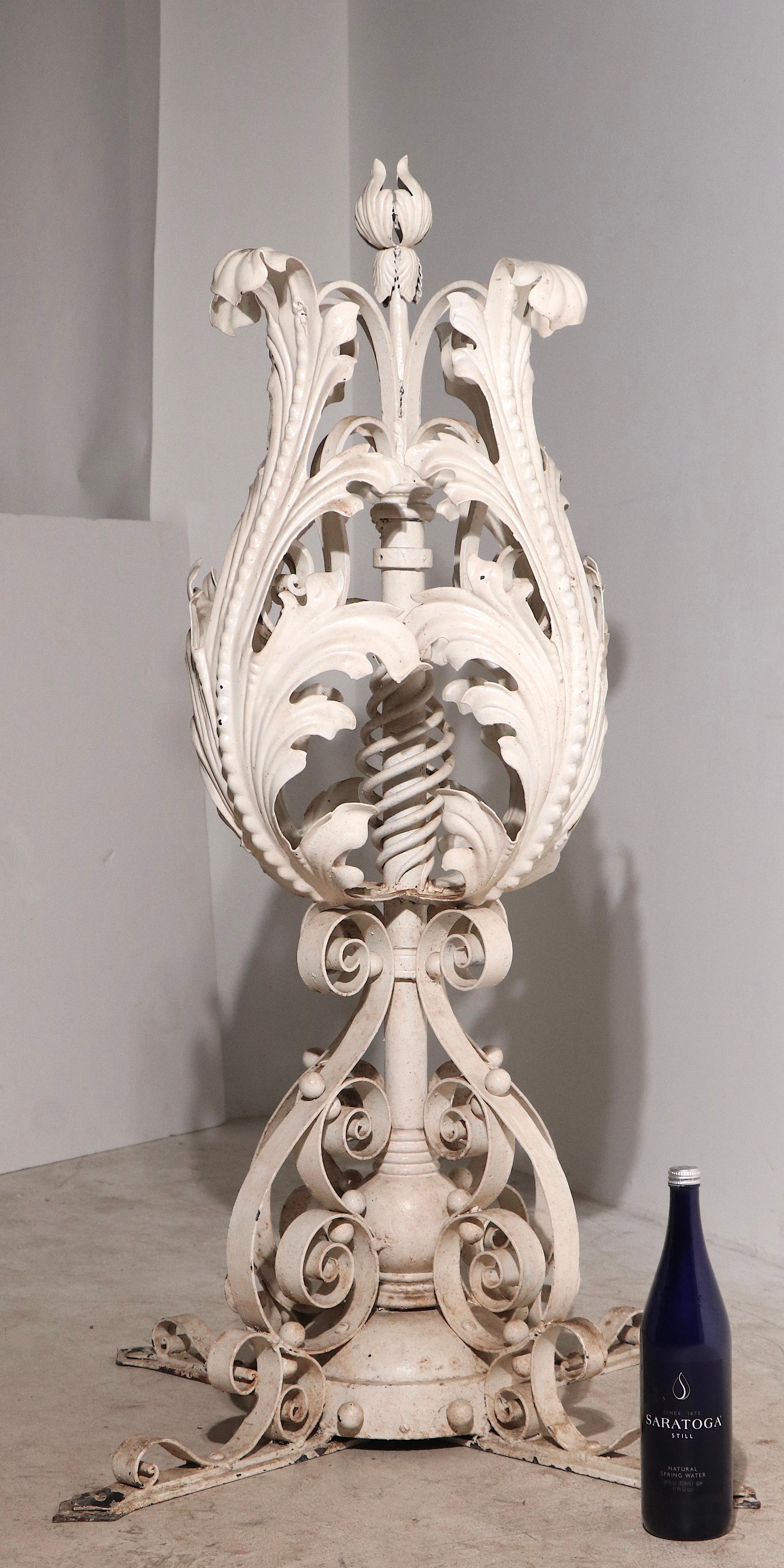 Incredible pair of wrought iron finials, probably originally placed on a brick wall as  decorative elements at an entrance. The finials feature foliate like wrought leaves on the upper  exterior, with decorative scroll work creating the four prong