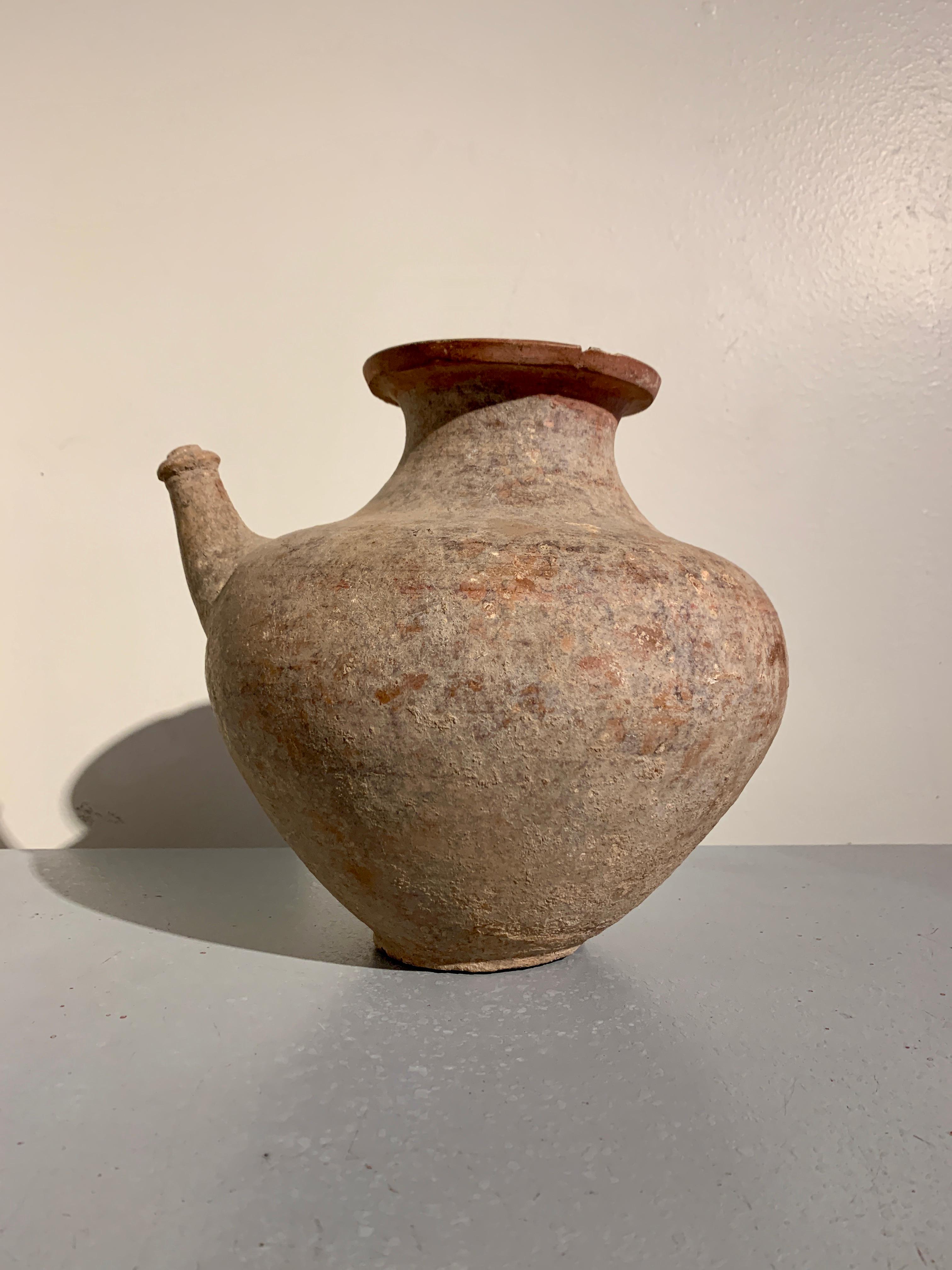 Un grande e attraente kendi, recipiente per versare, in ceramica rossa pre-Khmer, del VI-VIII secolo, Cambogia. 

Il grande vaso è realizzato in ceramica rossa, con un corpo ampio e globoso che poggia su un piede stretto, rotondo e dal fondo piatto.