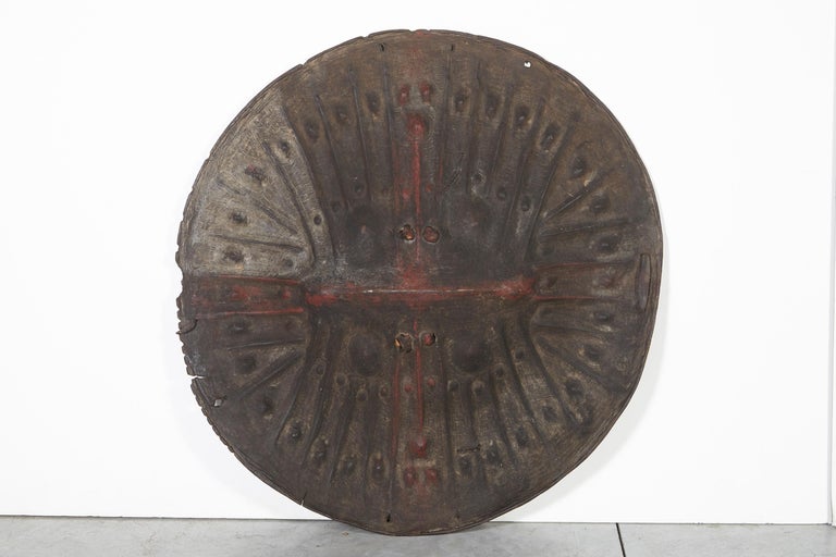 A beautifully sculptural and three dimensional animal hide shield from Ethiopia. This fabulous handmade  object was formed by carefully shaping the leather over stones to create its distinctive pattern and appearance. This piece displays wear as