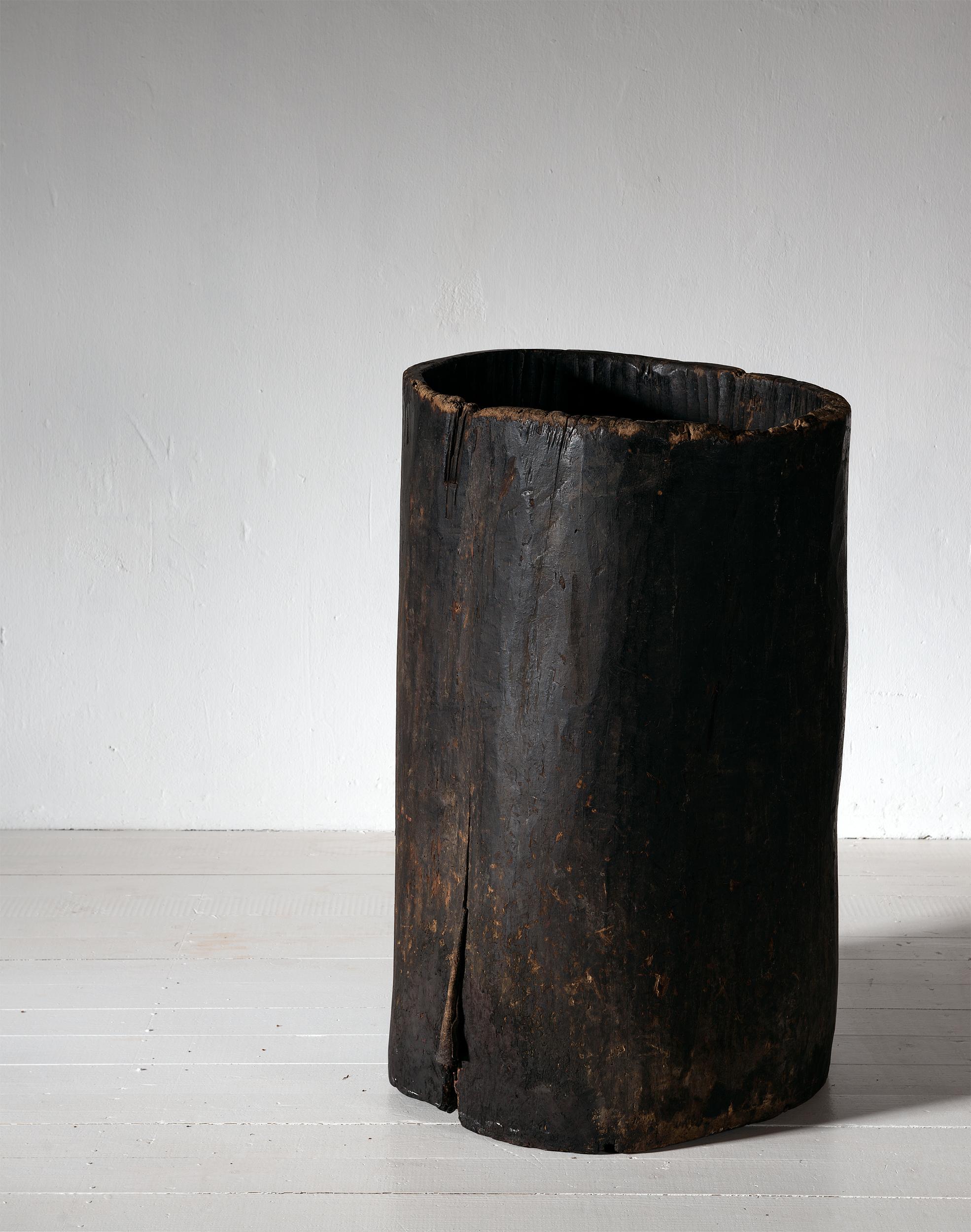 An early 19th century large grain storage barrel, carved from a whole tree trunk, of natural tapering cylindrical form. 
Perfect for use as a planter or for walking sticks and umbrellas, or just as beautiful, organic sculpture in a modern or