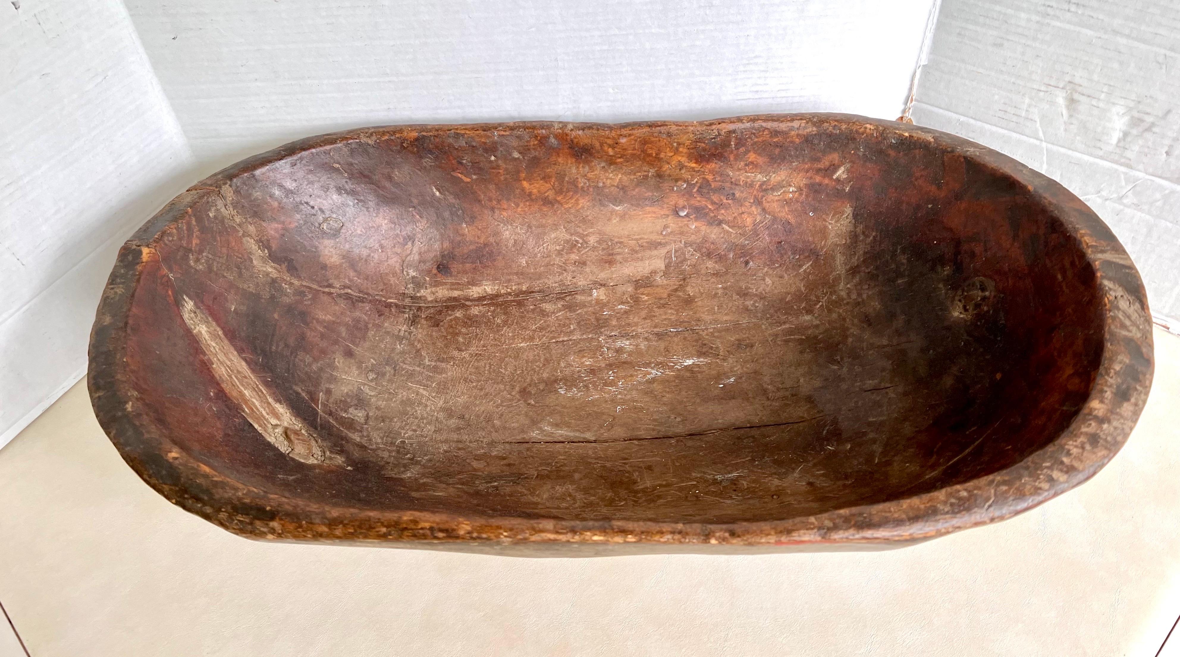 Handcrafted large wooden dough bowl hand carved from one piece of wood. Has a beautiful patina only acquired through its age and use.