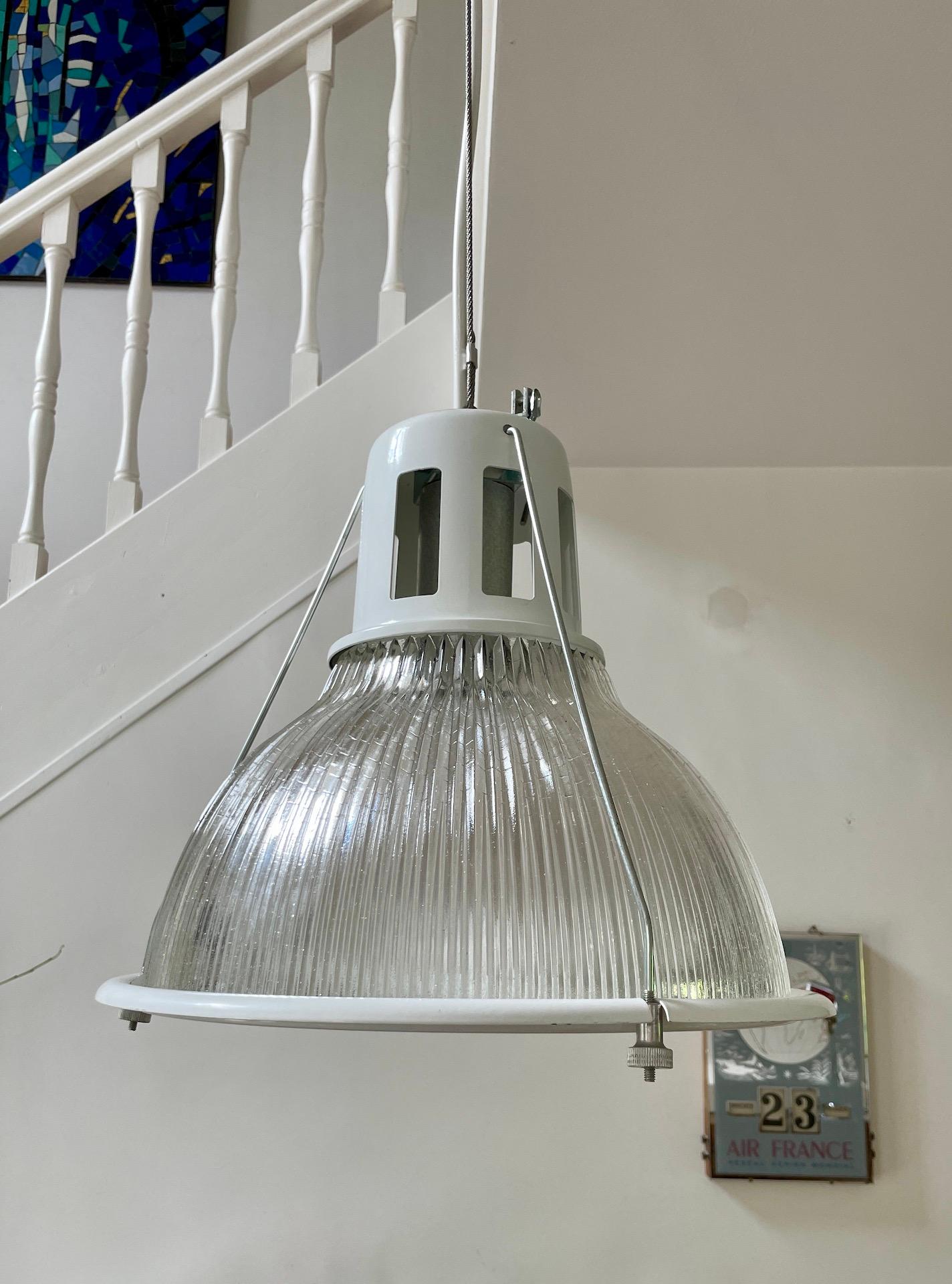 Questa lampada industriale è prodotta dalla famosa azienda Holophane, che ha creato la prima illuminazione prismatica negli Stati Uniti alla fine del XIX secolo.
Il vetro prismatico permette di proiettare la luce tutto intorno al paralume;