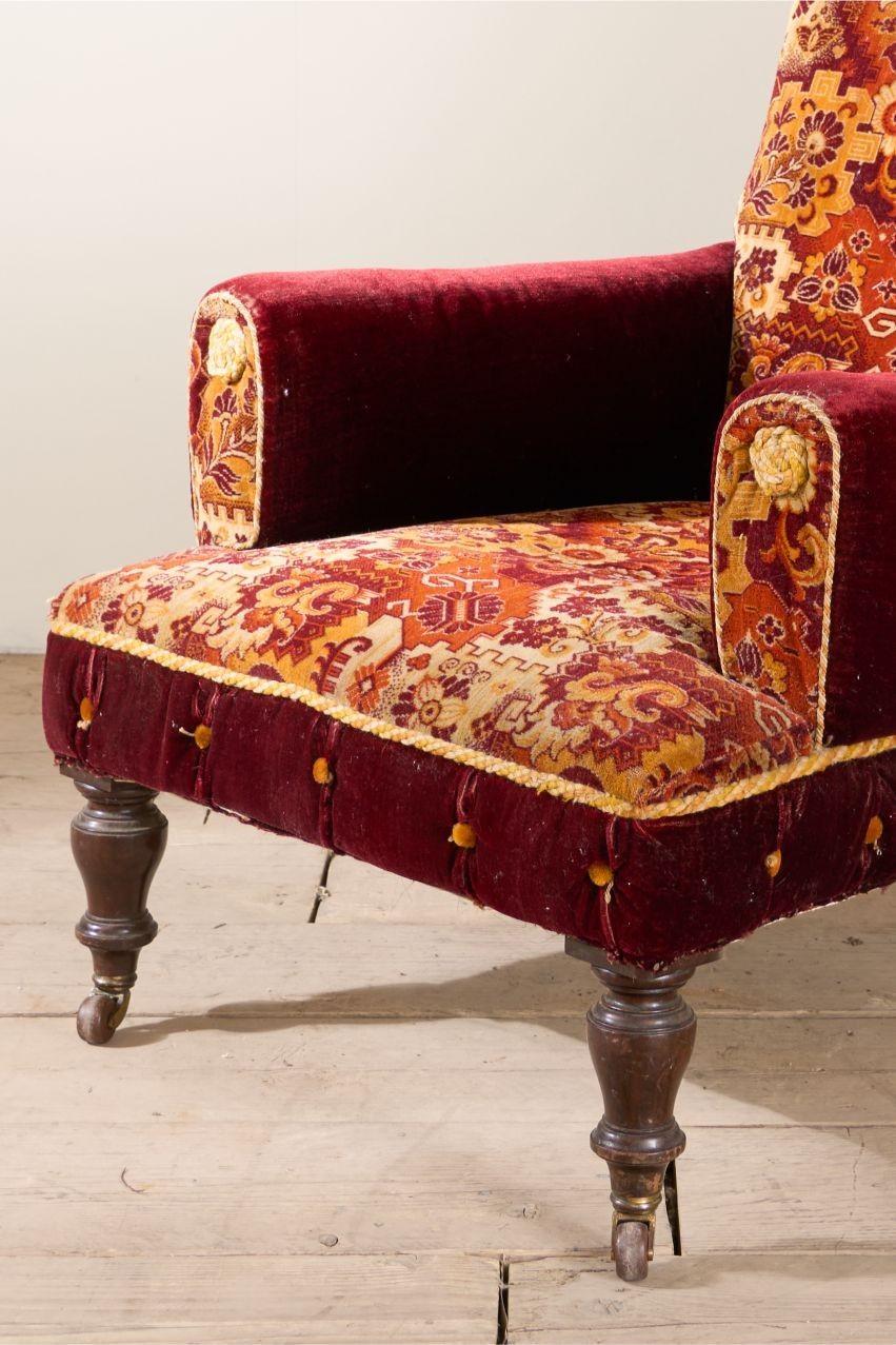 C'est toujours une joie lorsque je trouve ces chaises victoriennes originales recouvertes de tapis. Ce modèle est particulièrement grand et présente un design inhabituel avec le dossier à volutes et les accoudoirs en forme de coussin. La moquette