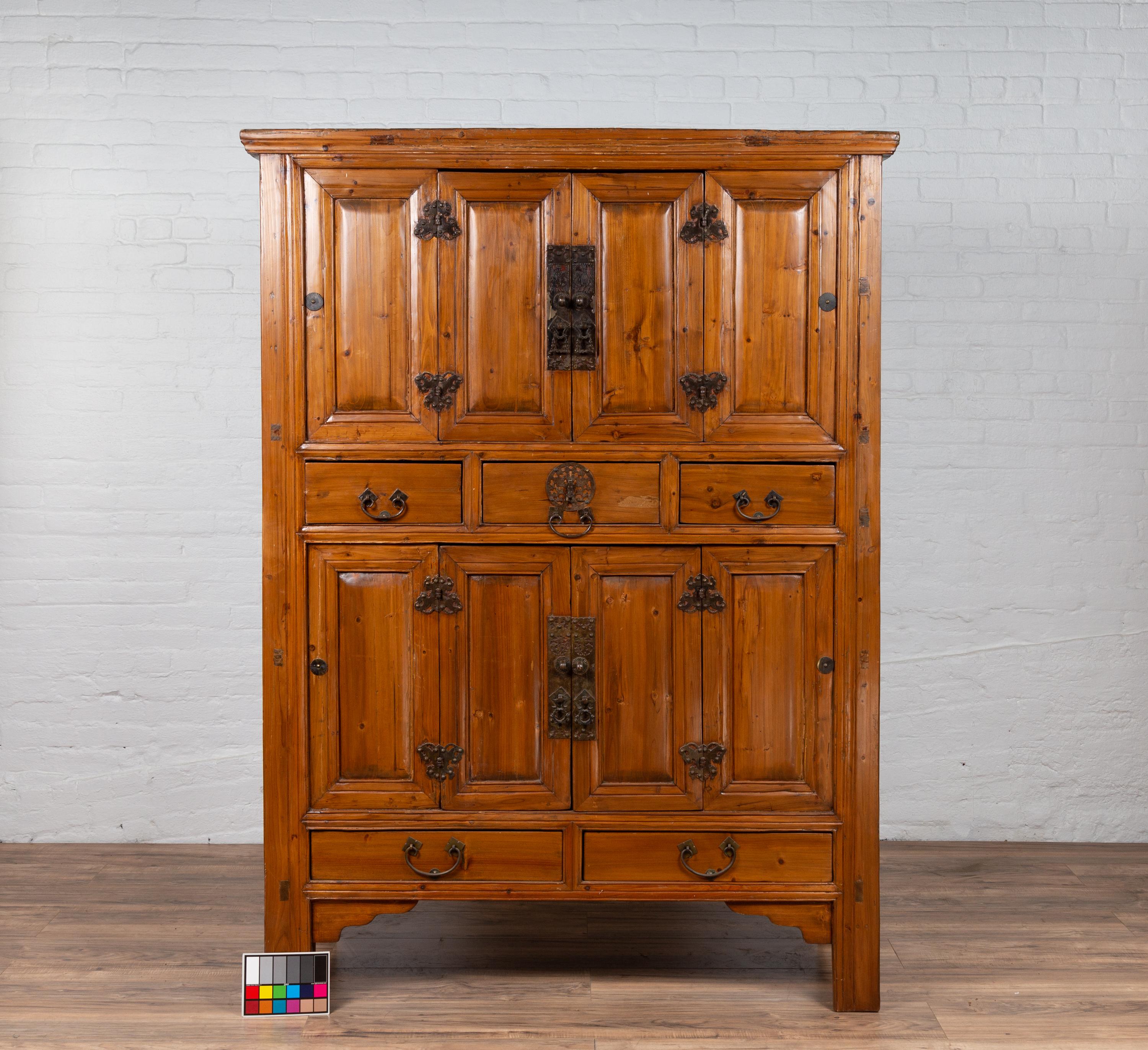 Cabinet en bois de la dynastie Qing, datant de la fin du XIXe siècle, avec des portes à panneaux, des tiroirs et des ferrures en forme de papillon. Créée en Chine à la fin du XIXe siècle, cette exquise armoire en bois de la dynastie Qing respire