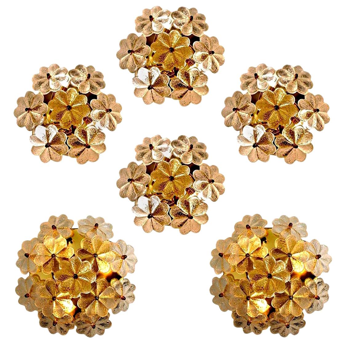 Large sculptural wall sconces have the design of a bouquet of textured glass flowers and are from the historical lighting company Ernst Palme. Each clear glass flower shade has textured petals and is securely screwed in place to the frame with a