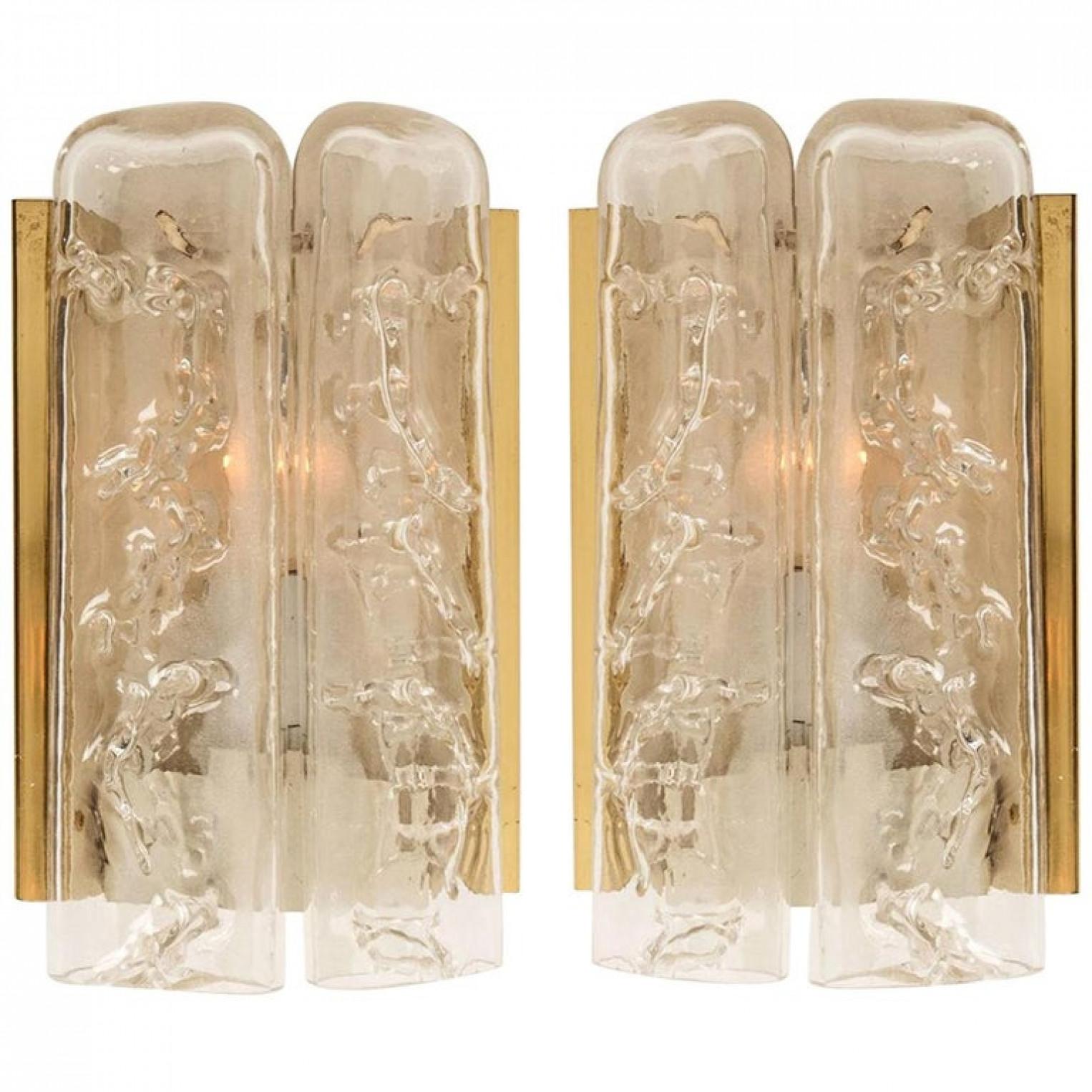 This set of blown wall sconces date from the 1960s and were created by the iconic firm of Doria Leuchten in Germany. They are fabricated with a backplate in white and brass and with two molten-glass, flat tubular prisms. High-end pieces

Two sizes