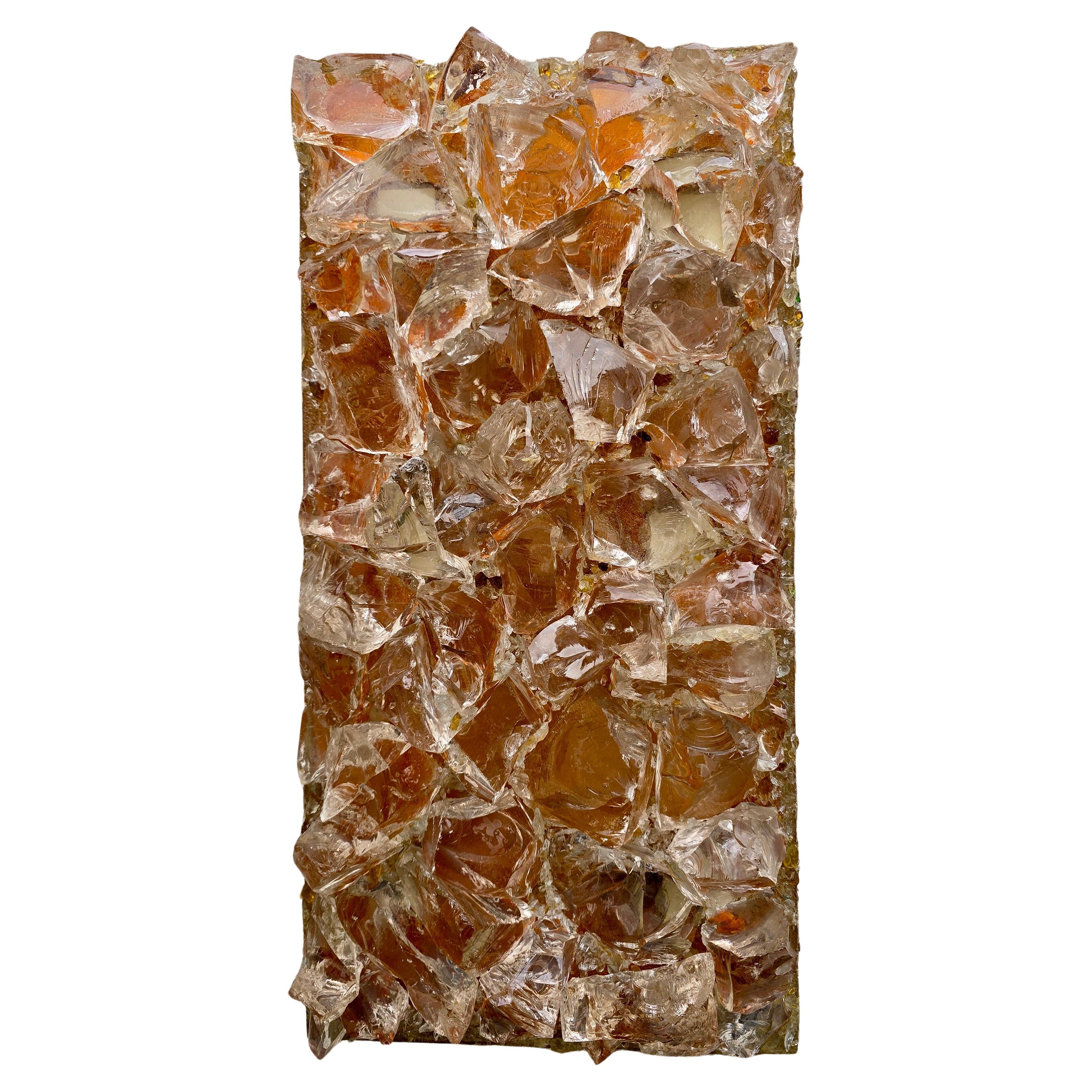 Llamativo aplique escultórico de Raak Amsterdam, Países Bajos, década de 1970.

Este gran accesorio rectangular está compuesto por trozos irregulares de cristal transparente texturizado montados en un marco de resina. Mientras que el cristal en sí