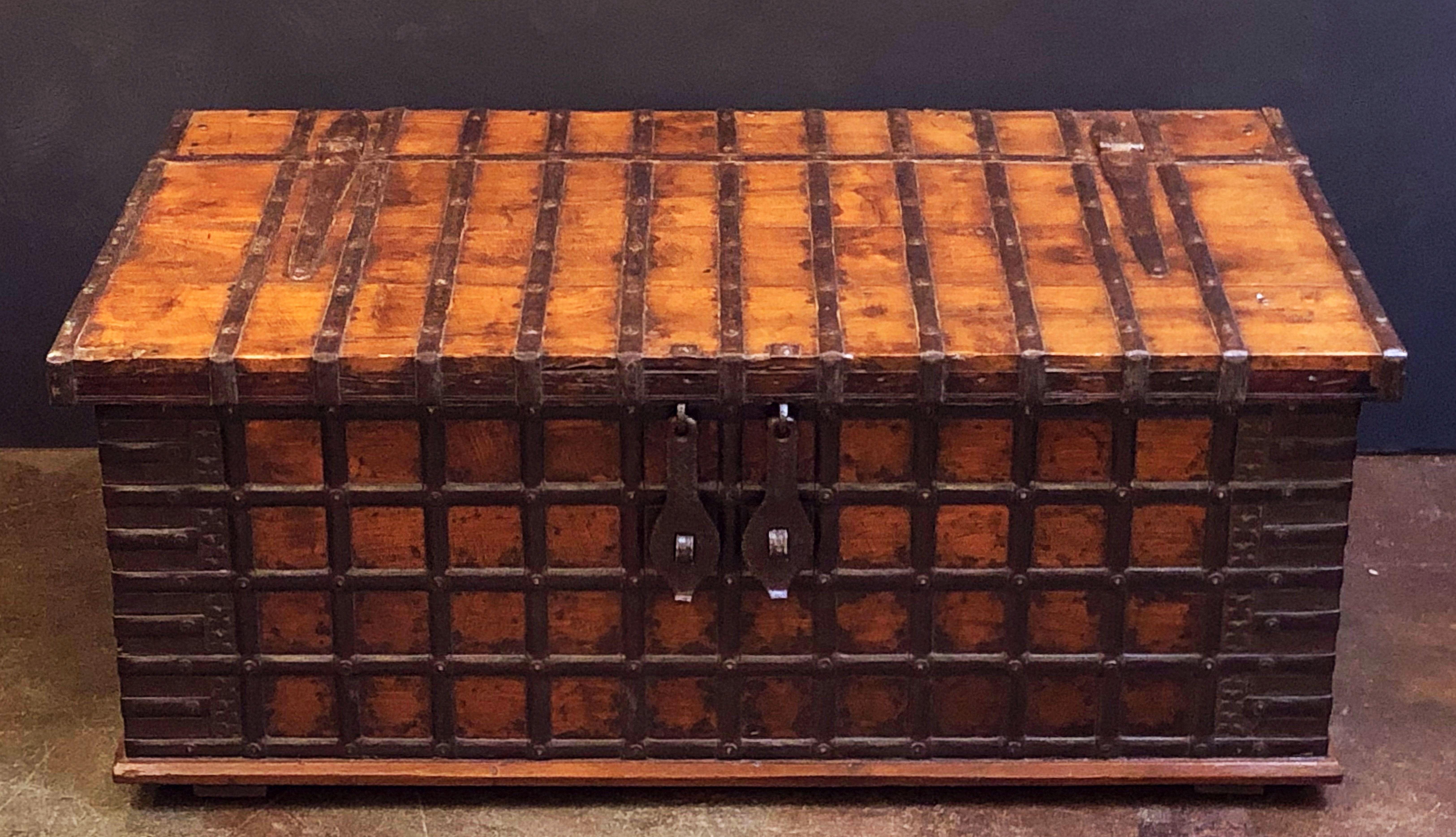 A handsome large 19th century rectangular iron-bound wooden coffer box or Rajasthan trunk from British Colonial India (The Raj) featuring a hinged top hatch with storage inside. 

Traditionally used for patio storage in Indian havelis - Makes a