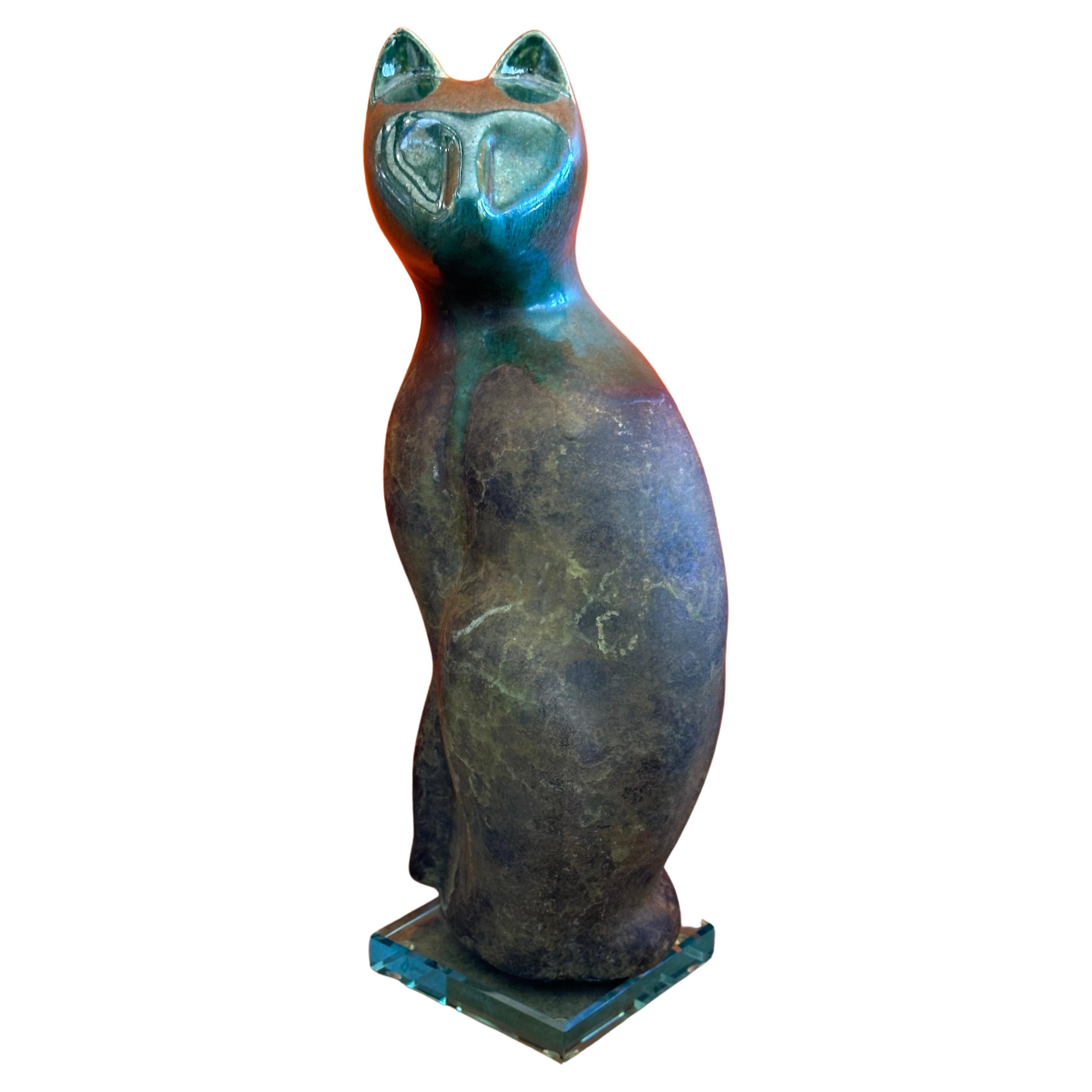Eine sehr schöne große sitzende Katze aus Raku-Keramik auf einem Sockel aus Lucit von dem bekannten Künstler Tony Evans, ca. 1980er Jahre. Das Stück ist auf dem Sockel signiert und sehr gut verarbeitet; es hat wunderbare grüne und braune Farben und