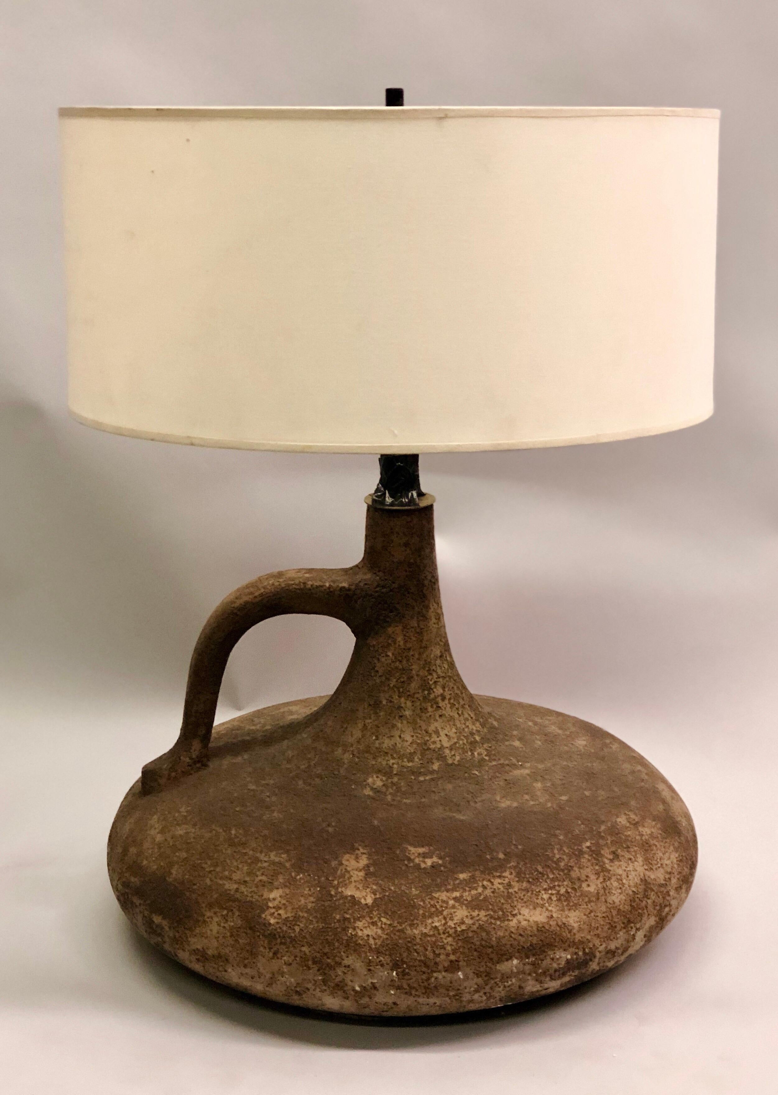 A large, artist handmade, French midcentury urn form ceramic table lamp in the Brutalist tradition emphasizing the raw nature of the clay material counterbalanced with a singular exquisite form.

Height to stem is 15