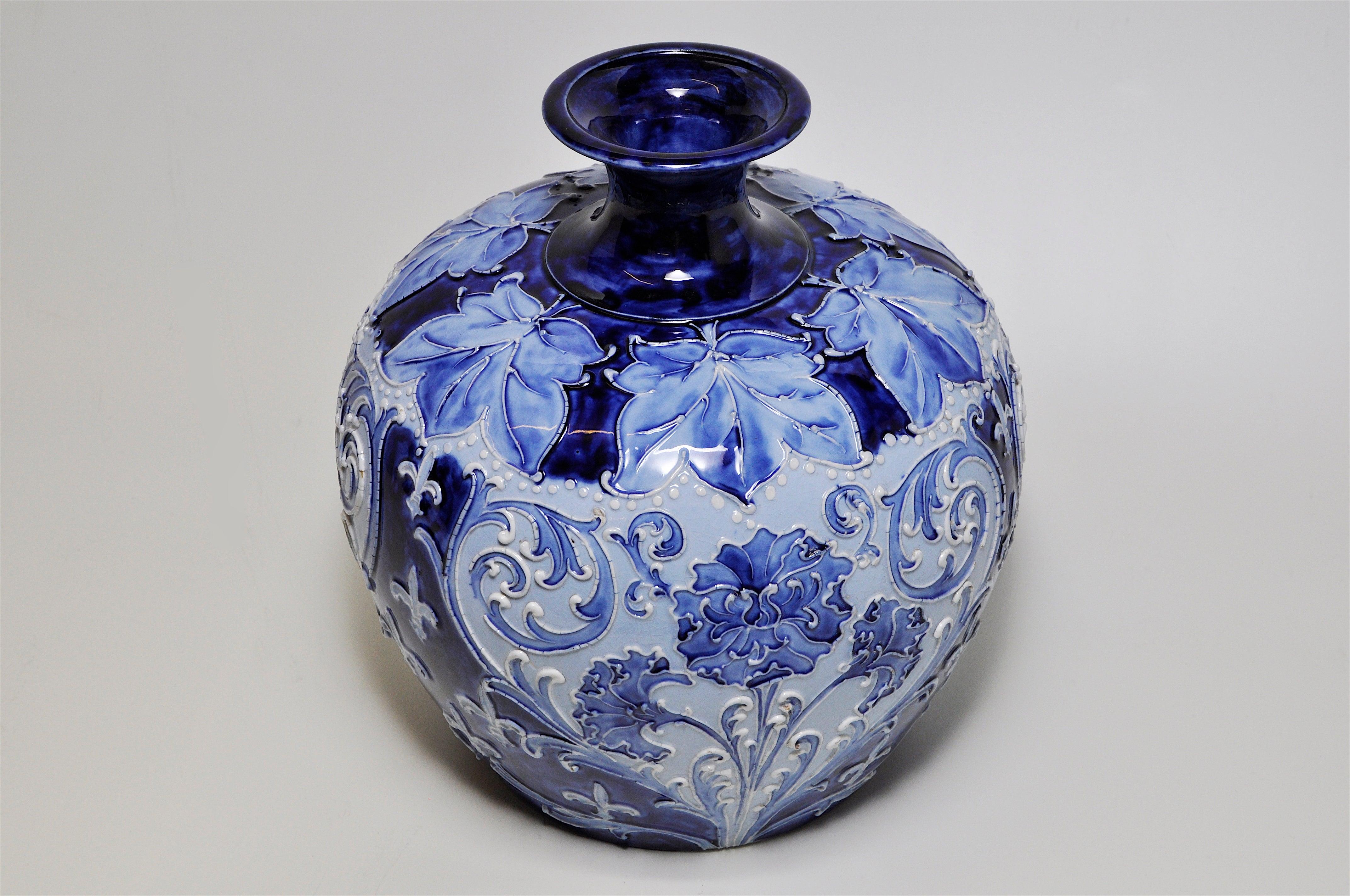 A fabulous large William Moorcroft Florian ware ceramic vase in striking blue and white with a highly decorated surface of finely tube-lined trailed slip technique. The organic floral forms of stylized dianthus sprays and maple leaves flow over the