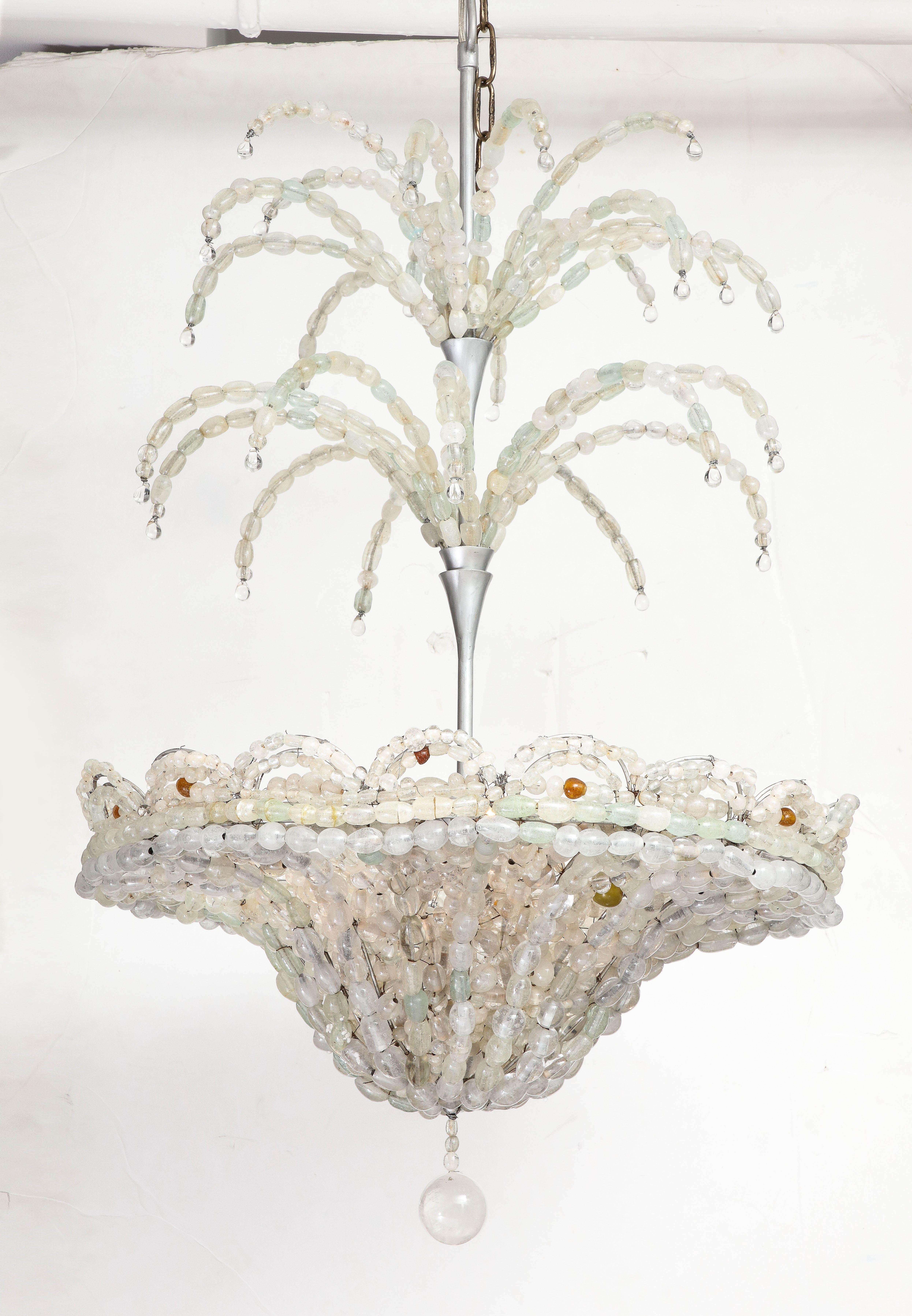 A rare and spectacular Art Deco chandelier comprised of a myriad of handblown beads strung together like pearls on a silver painted metal fountain form, the two tiers surmounting a scalloped edge beaded basket capped by a bottom ball. The