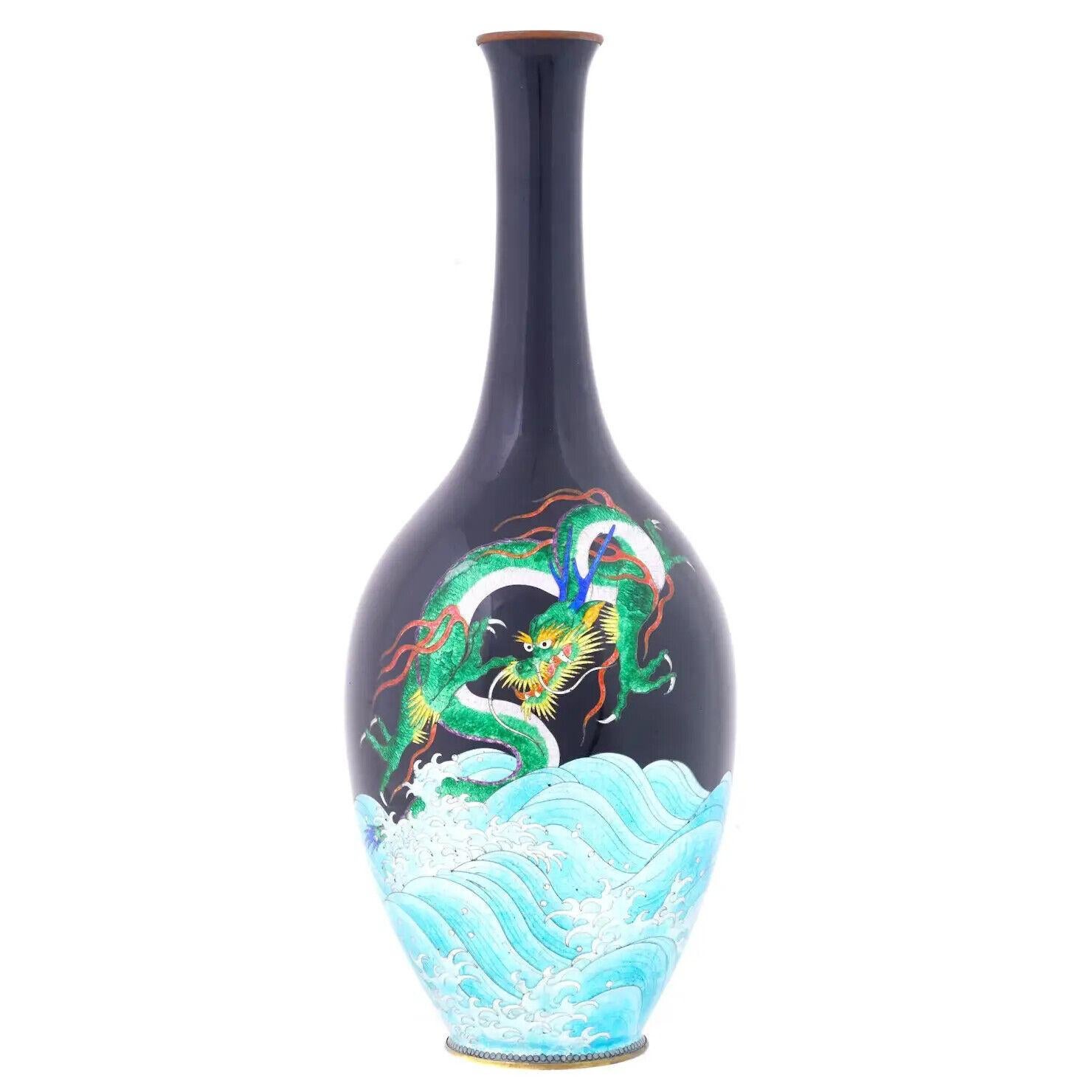 A high quality Japanese enamel vase, Meiji era, 1868 to 1912. The vase has an amphora shaped body and a narrow neck. The ware is enameled with a polychrome image of a big dragon over the sea made in the Cloisonne technique. Antique and Vintage Asian