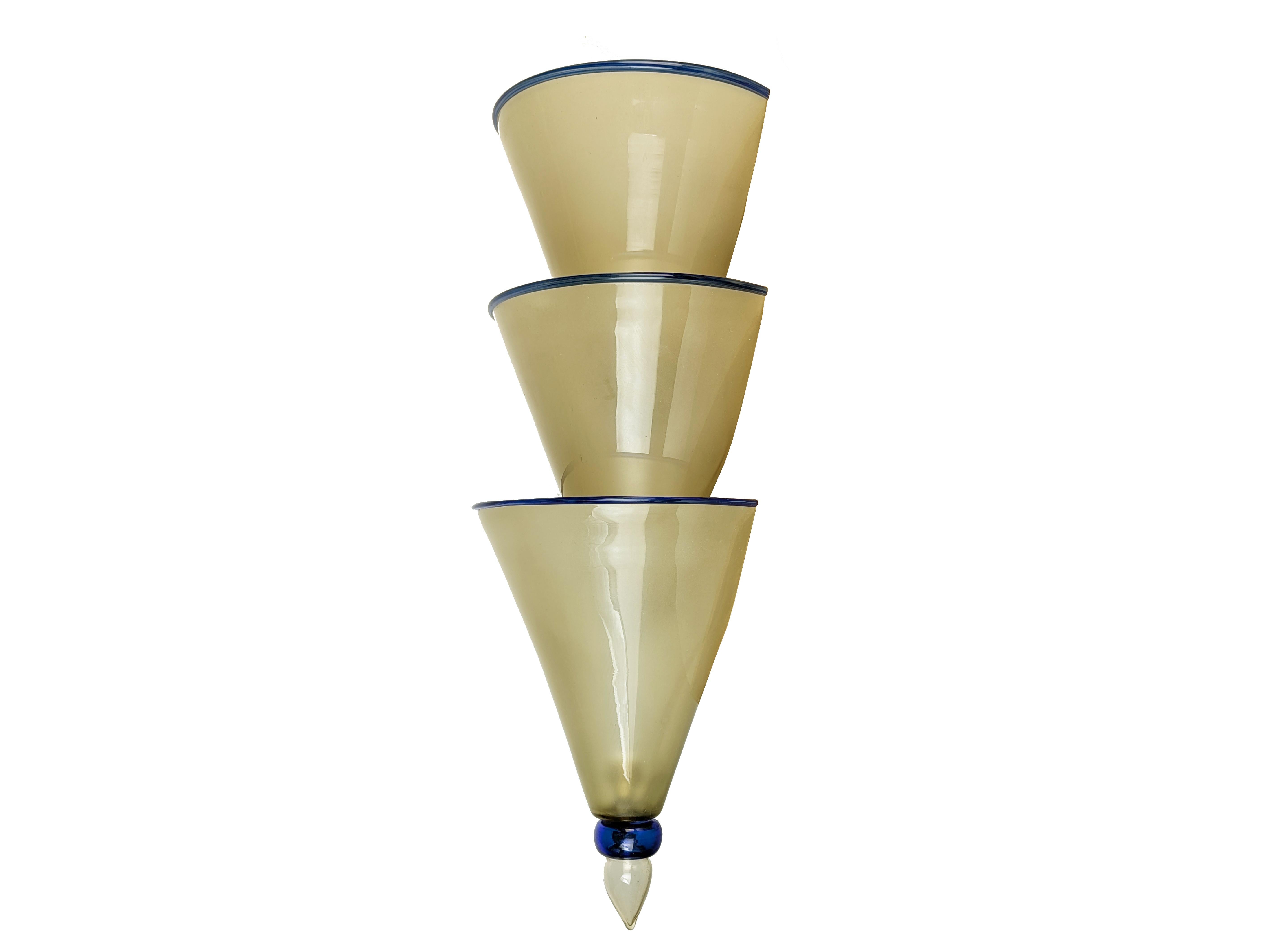 Bedeutendes Paar Art-Déco-Wandlampen, hergestellt in den 1930er Jahren in Murano, Italien. Jede Leuchte besteht aus 3 sandgestrahlten, strohgelben Glasschalen mit transparentem, blauem Rand. Die einzelnen Schalen, die derzeit auf einem Holzgestell
