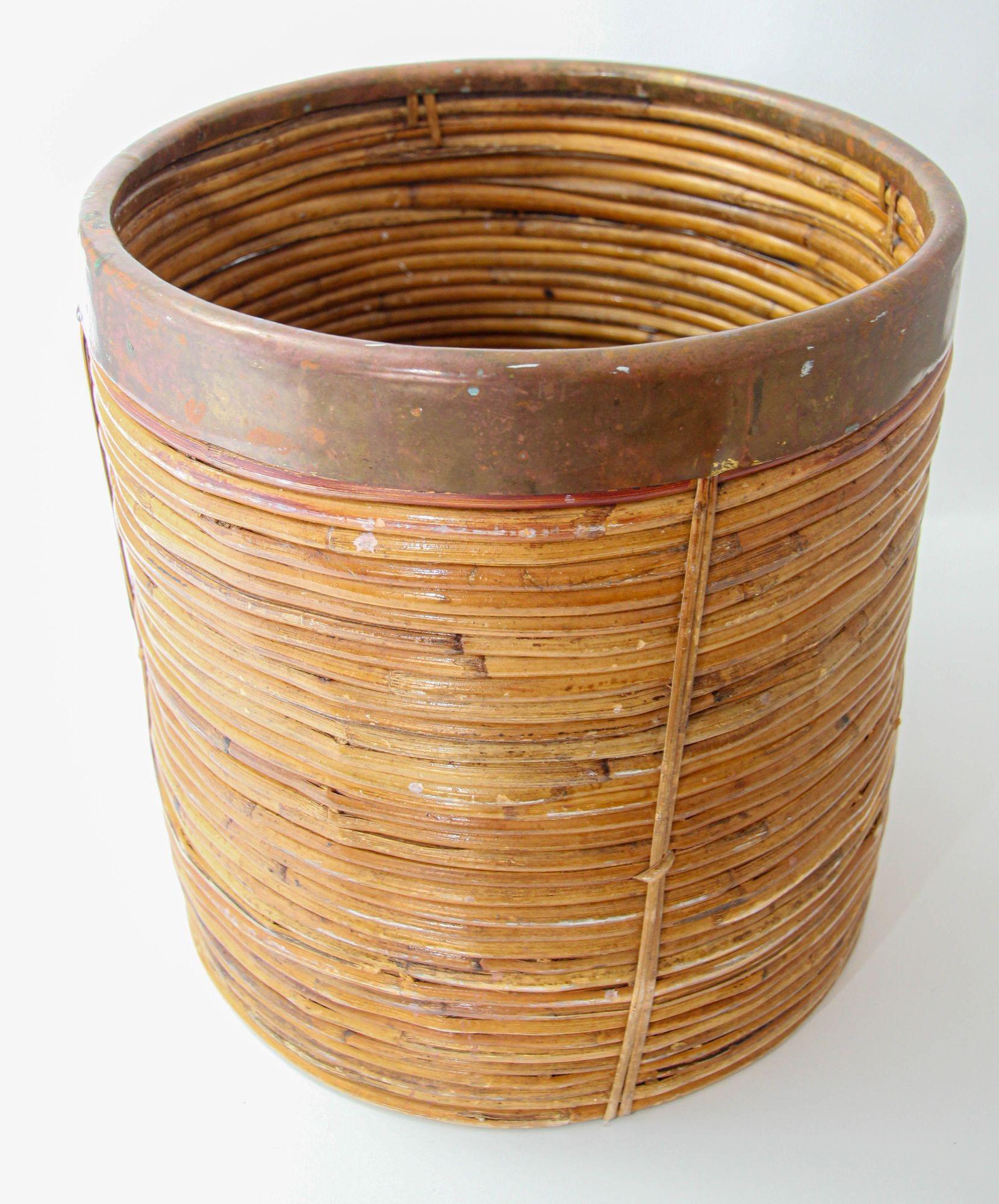 Bellissimo cesto o fioriera rotonda in rattan di bambù con bordo in ottone realizzato a mano in Italia negli anni '70.
Fioriera d'epoca Mid-Century Modern in ottone e rattan, realizzata a mano.
Cestino decorativo completamente realizzato in rattan