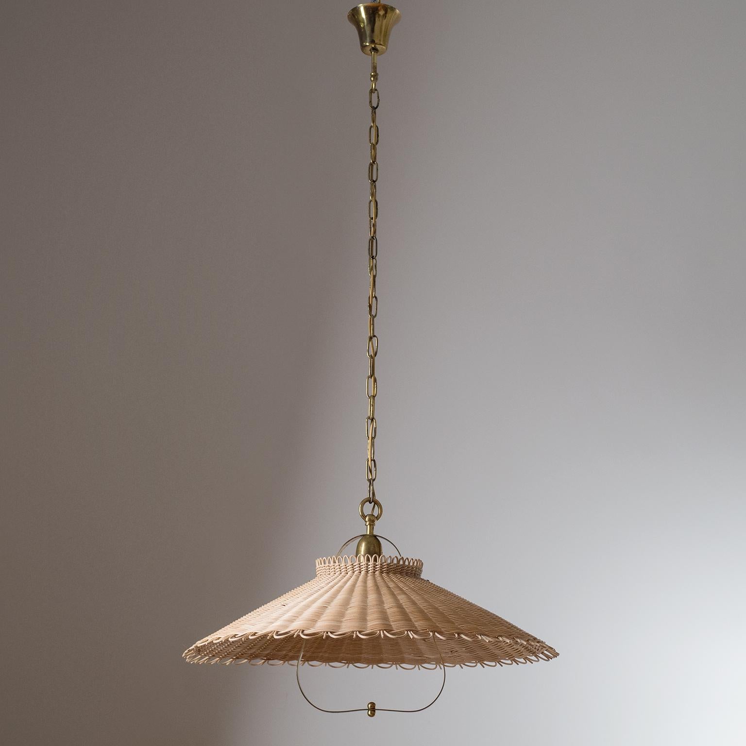 Rare large rattan pendant attributed to J.T. Kalmar, circa 1950. Large woven rattan shade with brass suspension and details. One original brass E27 socket with new wiring. Height without chain is circa 14inches/35cm.